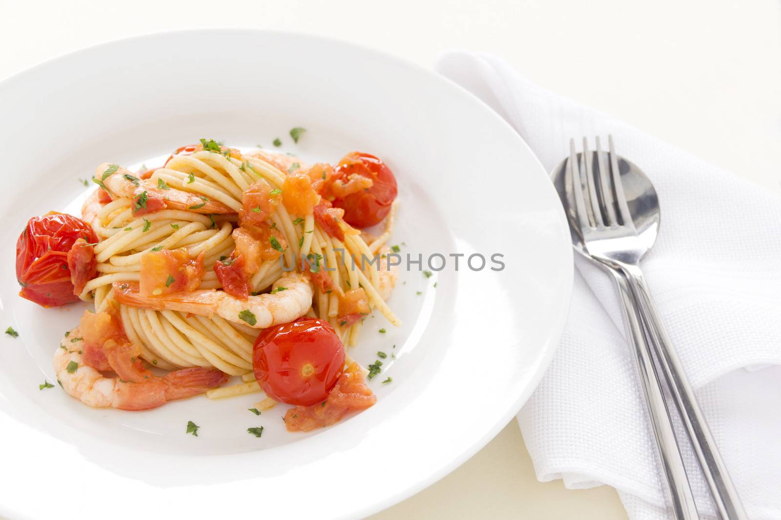 Delicious fresh shrimps and spaghetti with cherry tomatoes and parsley and allowing for copy space.