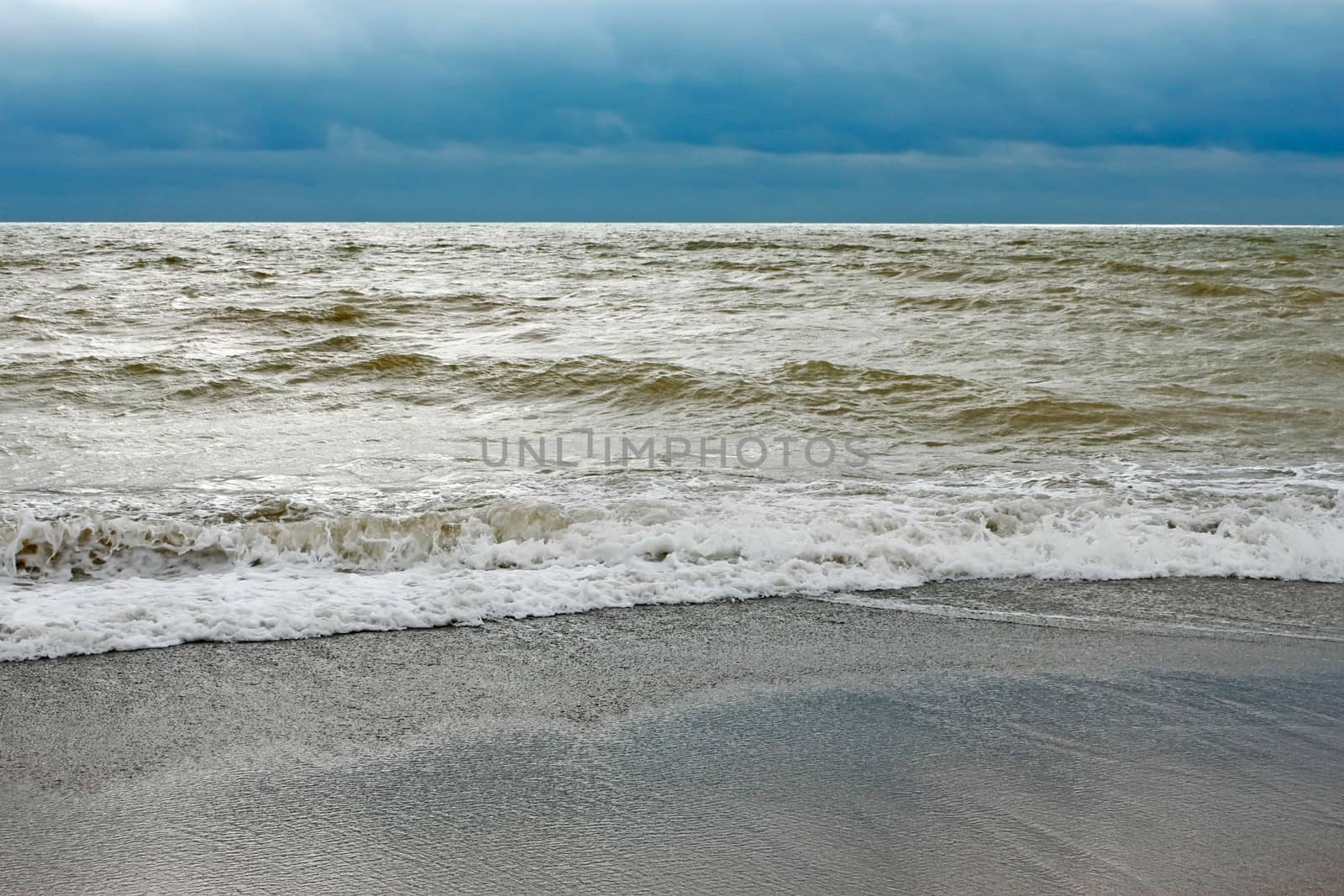 Sea coast after the storm with contaminated water with sand dredged from the seabed