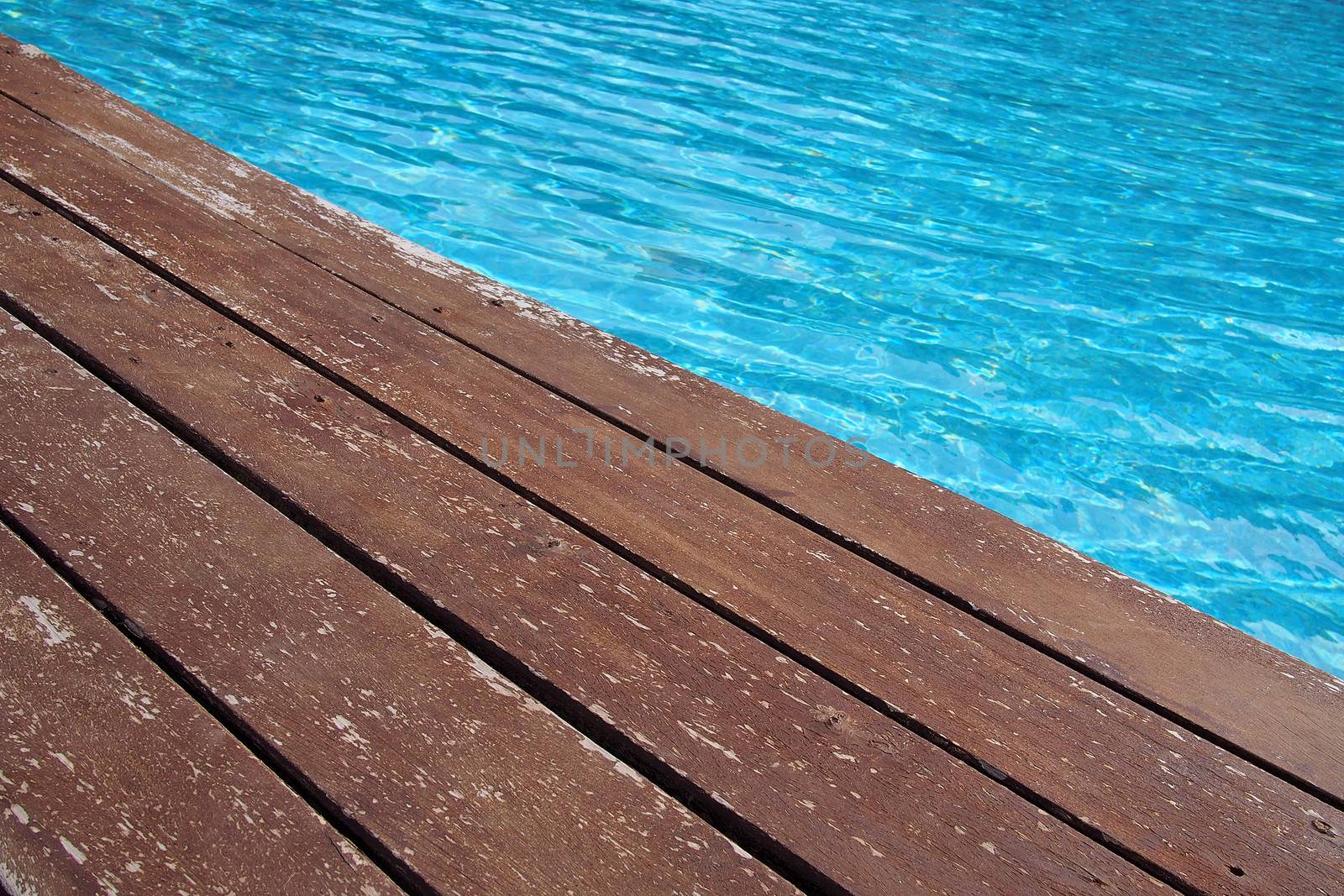 Swimming pool with a wooden flooring beside it