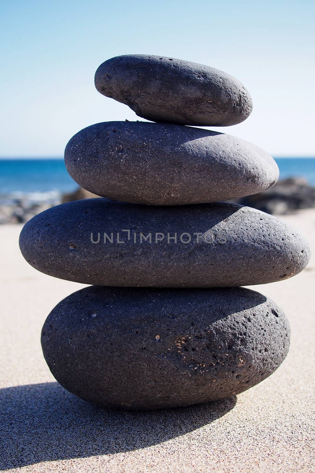 Isolated stacked zen stones near seashore by stockyimages