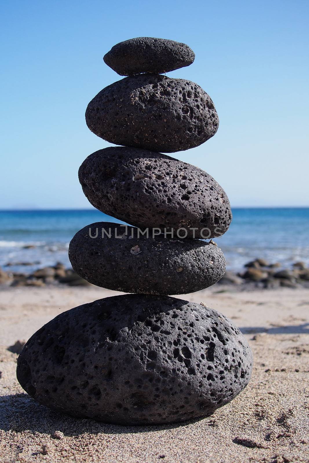Stack of zen stones near beach by stockyimages