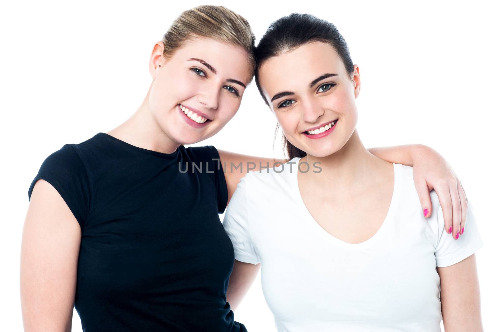 Two teenage friends smiling in front of camera by stockyimages