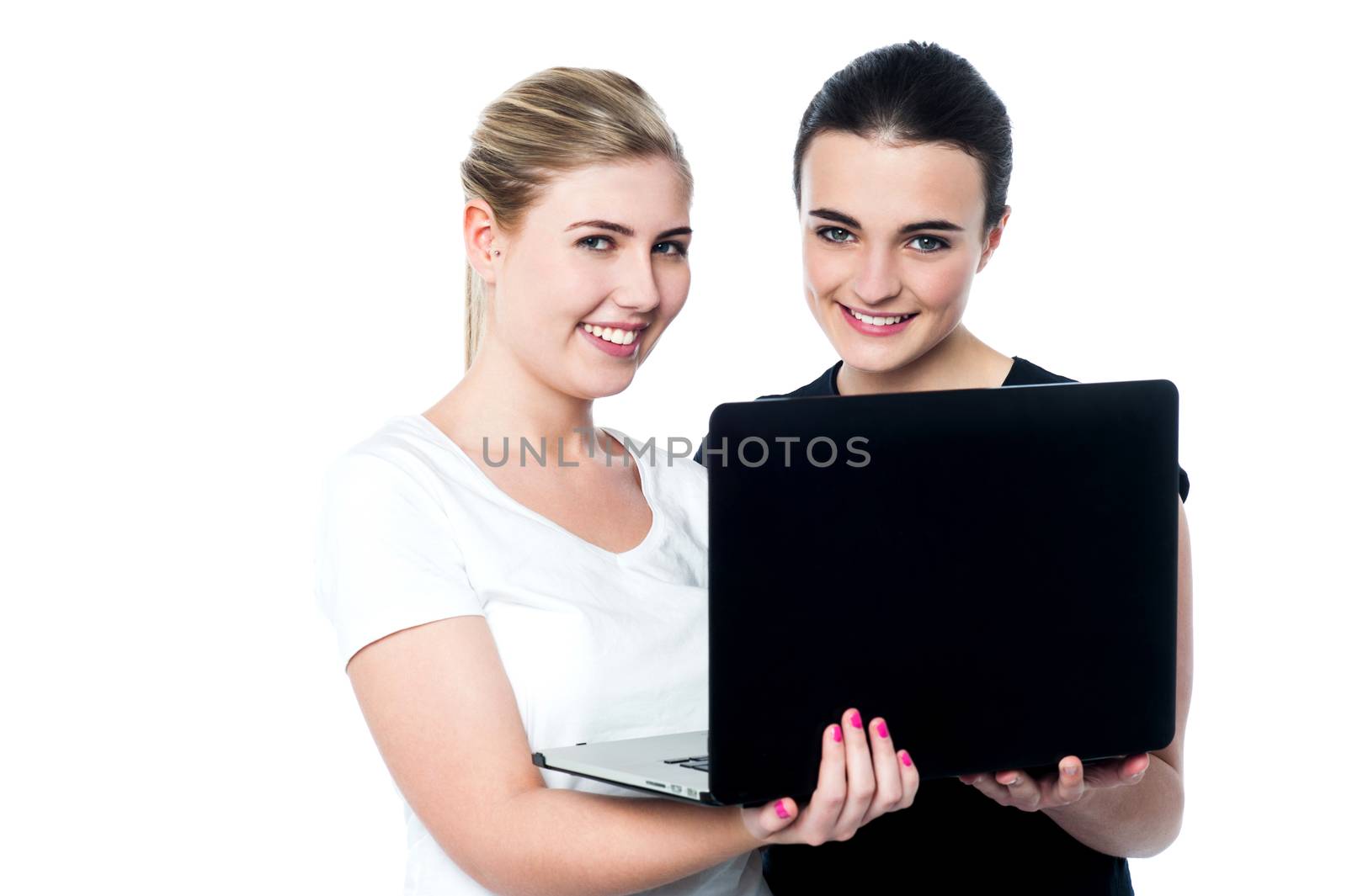 Smiling caucasian girls using laptop by stockyimages