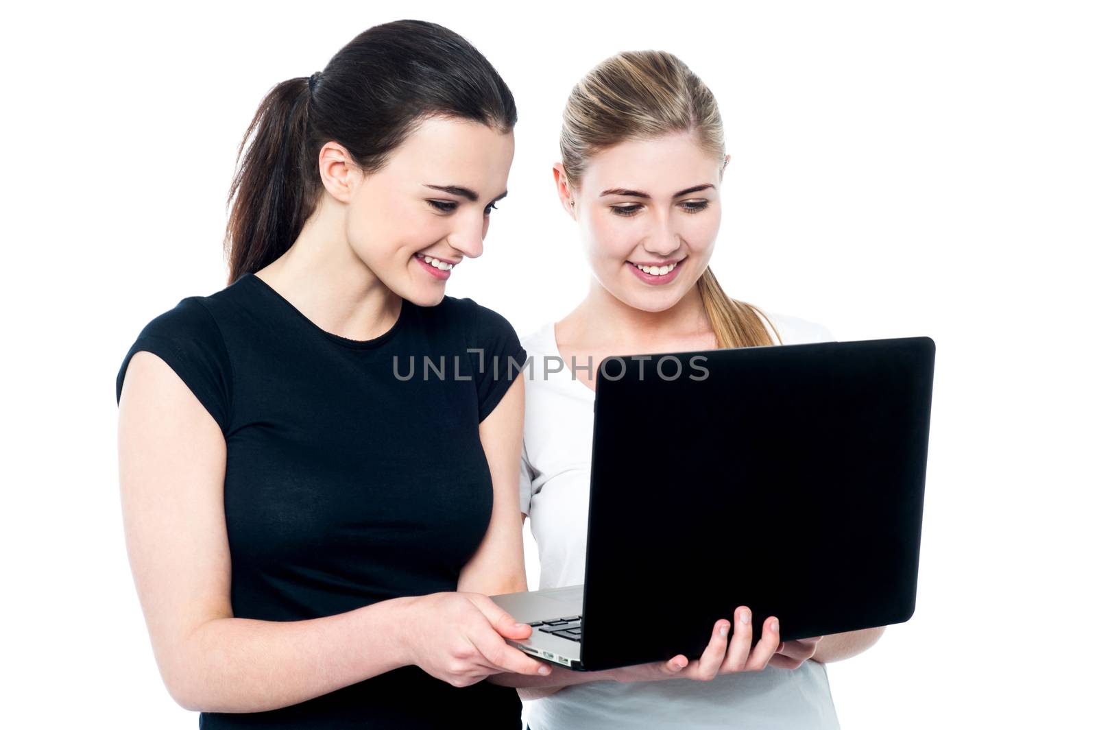Happy girls enjoying a funny video on their laptop
