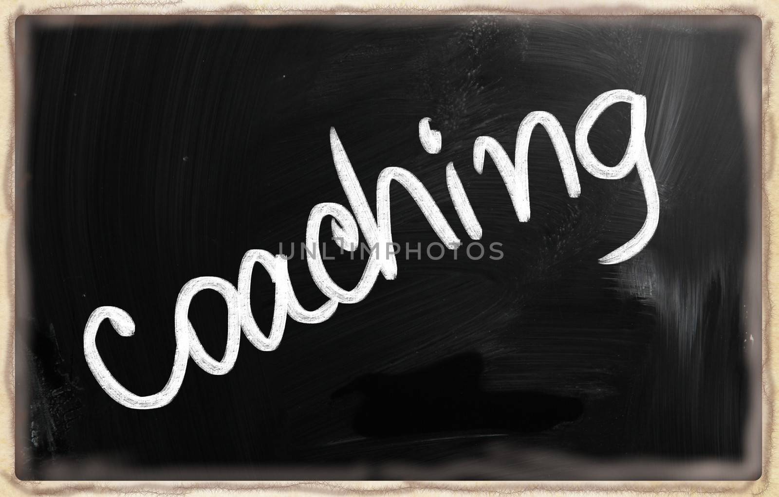 "Coaching" handwritten with chalk on a blackboard.