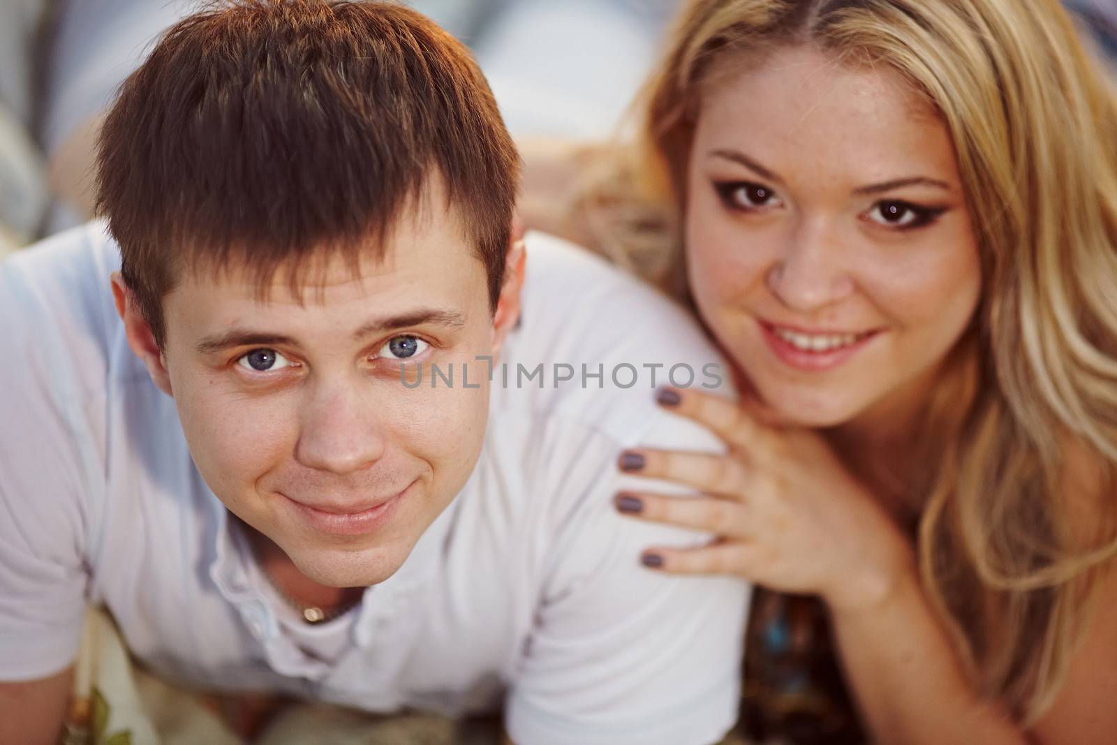 oung couple lying on the sunset background.