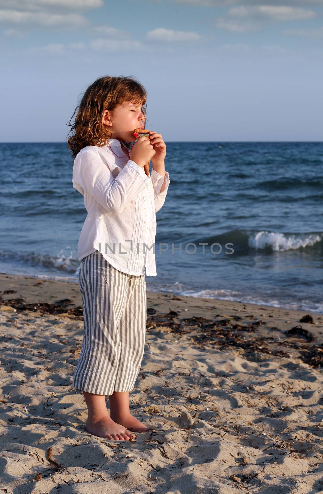 beautiful little girl play pan pipe on beach by goce