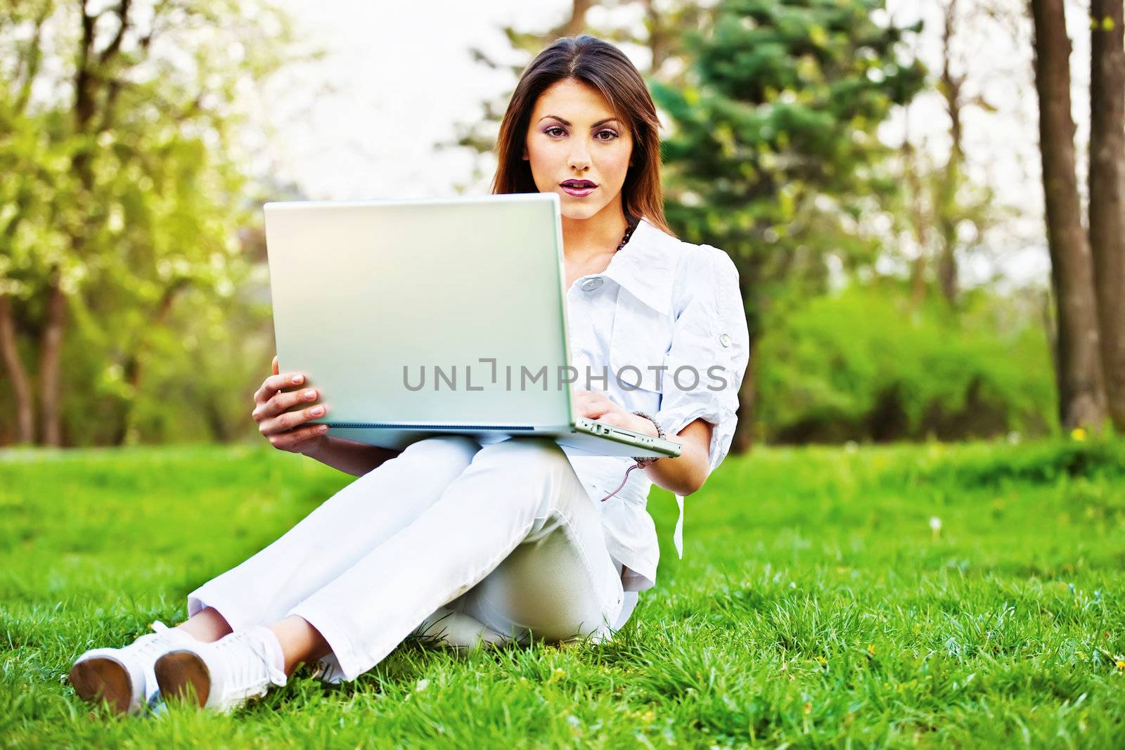 woman with laptop in park by imarin