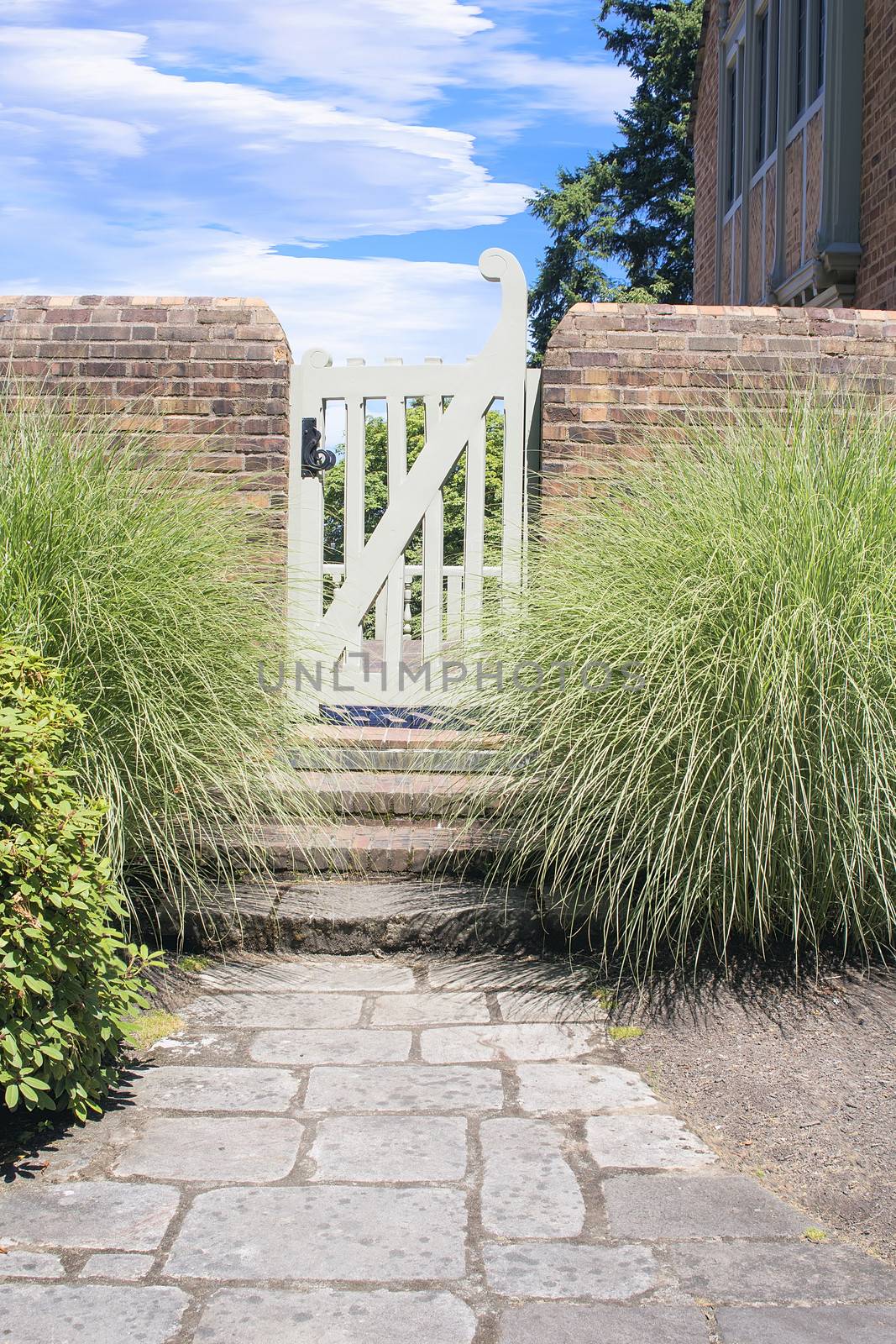 Natural Stone Path to Backyard Garden Gate with Brick Wall