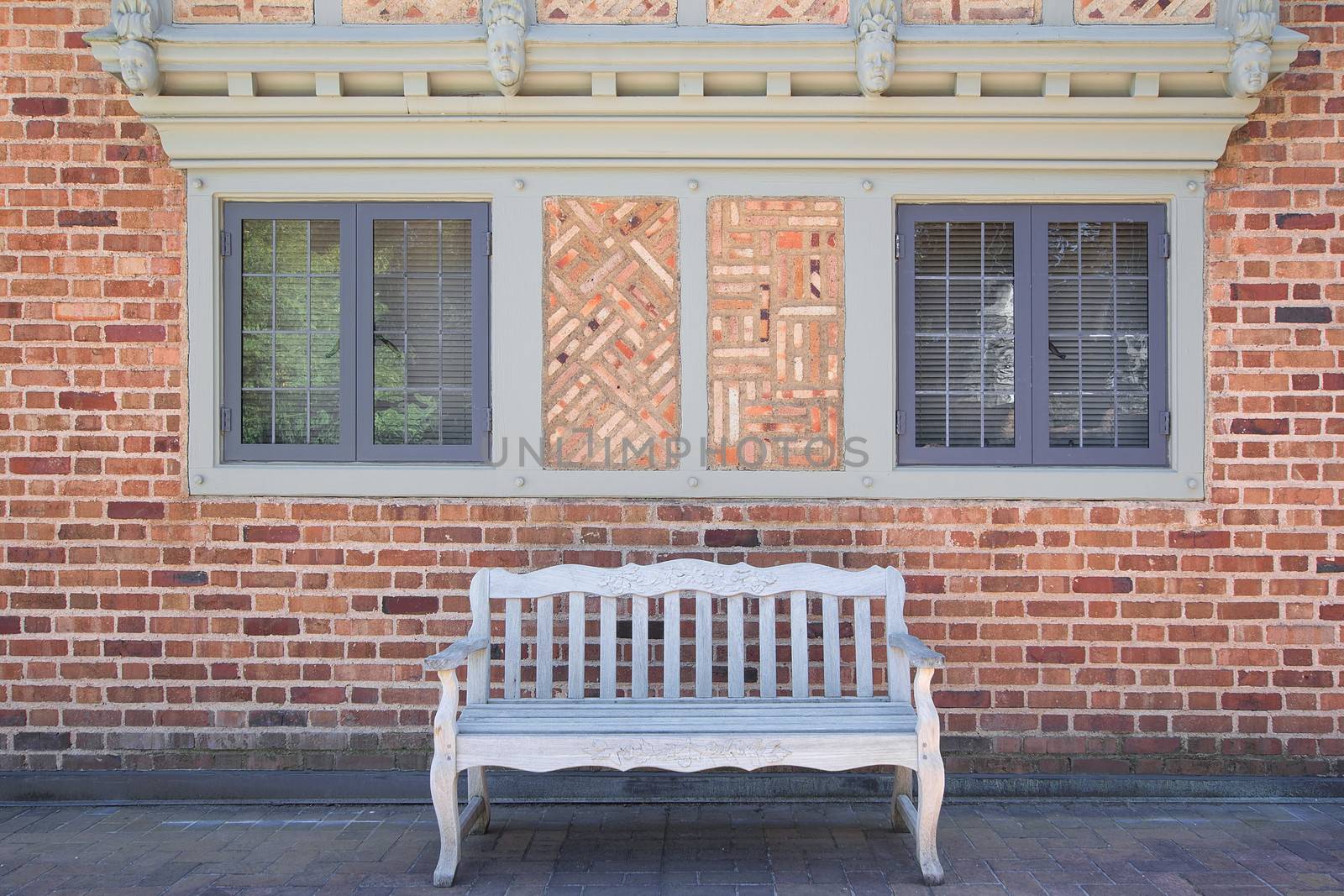 House Bricks Exterior with Windows Frame Stonework Design and Wood Bench on Paver Patio