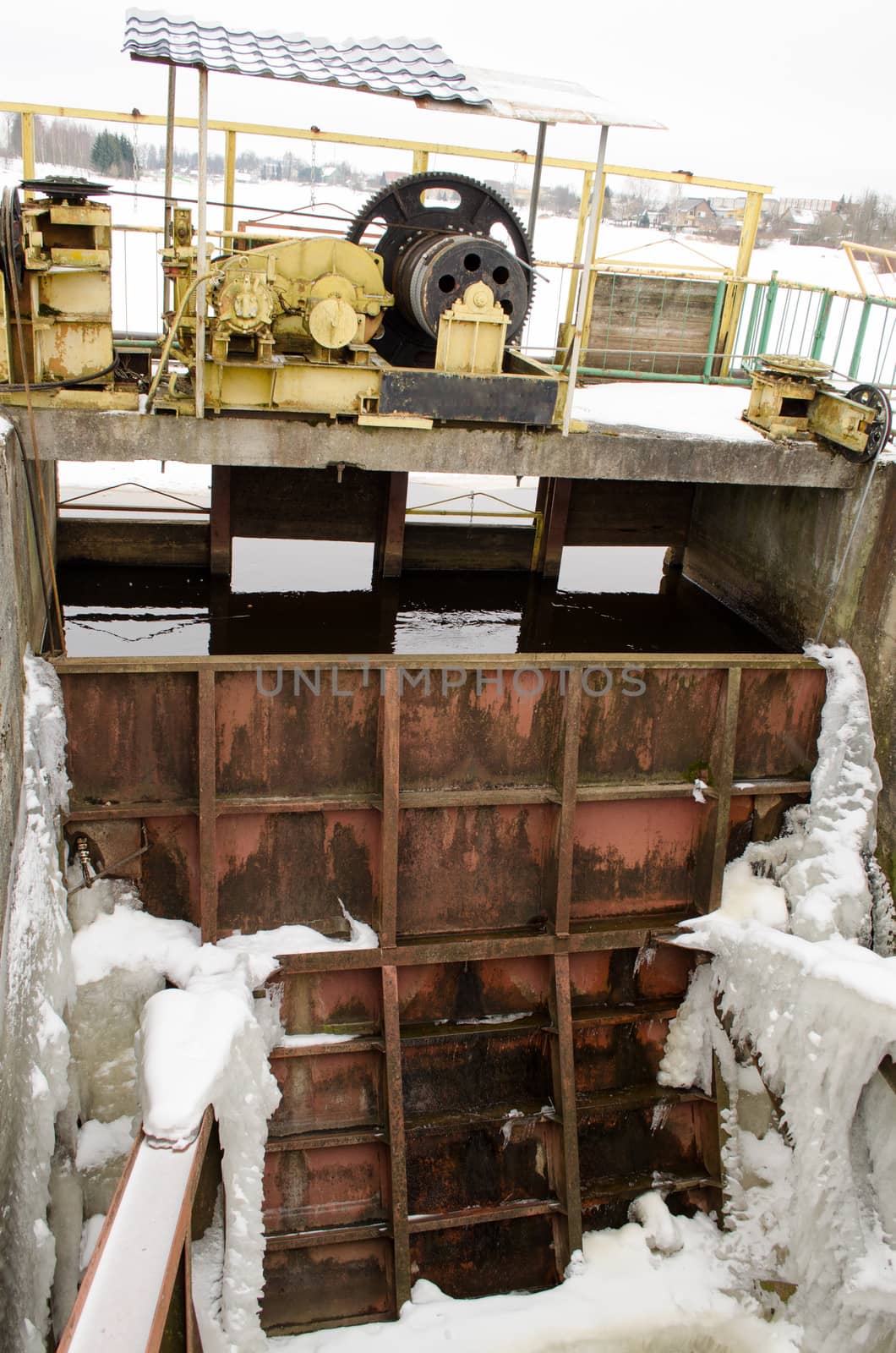 frozen river dam mechanism and gate in winter.