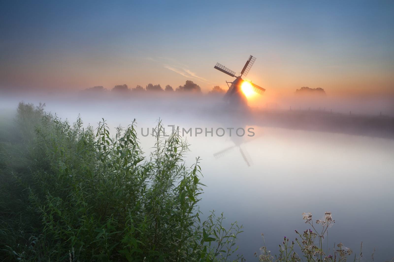 summer sunrise over river and windmill, Groningen, Netherlands