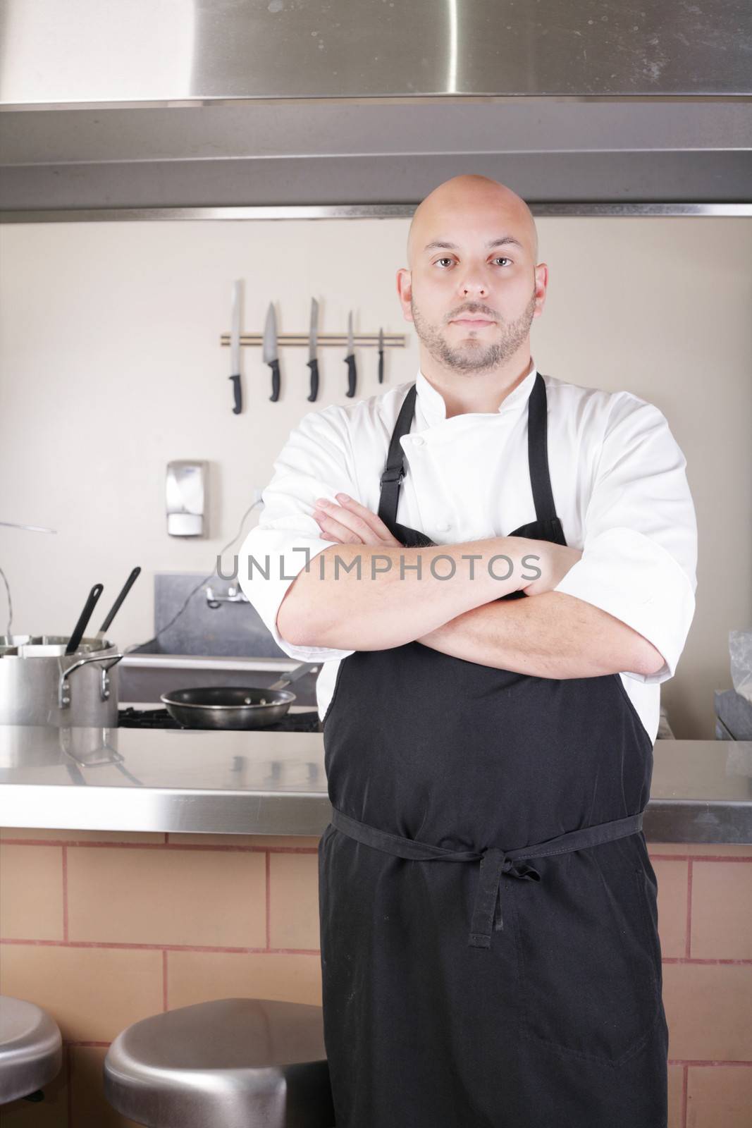 Male Chef Standing Next To Cooker In Kitchen