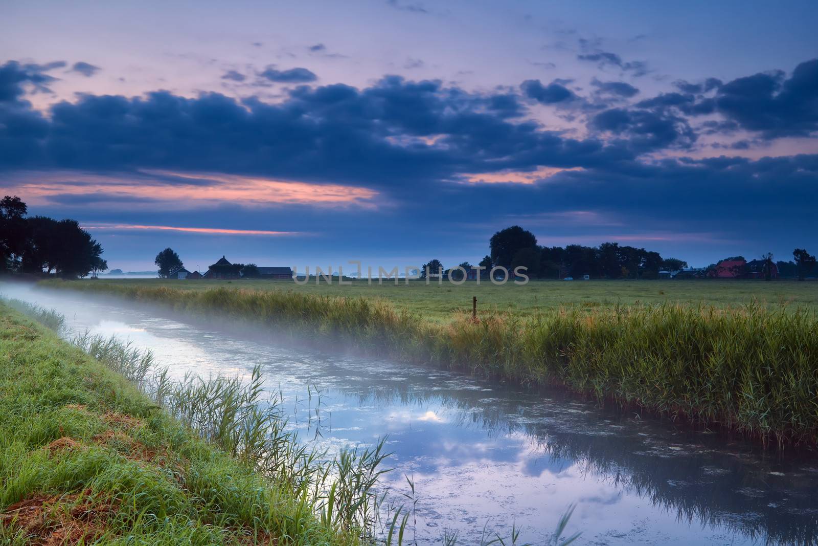 Dutch farmland with canal at dusk, Groningen, Netherlands