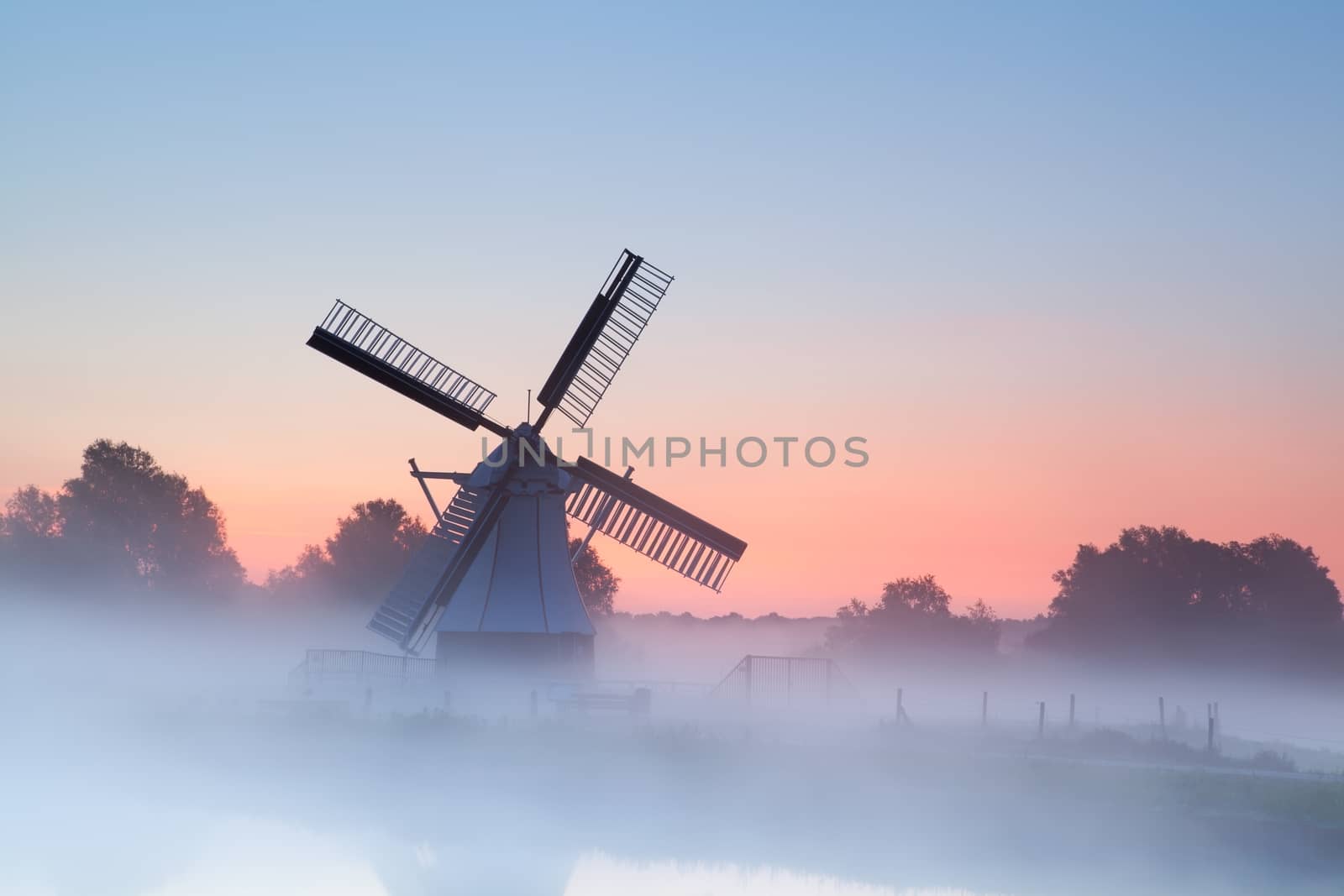 charming Dutch windmill in morning sunrise fog, Groningen, Netherlands