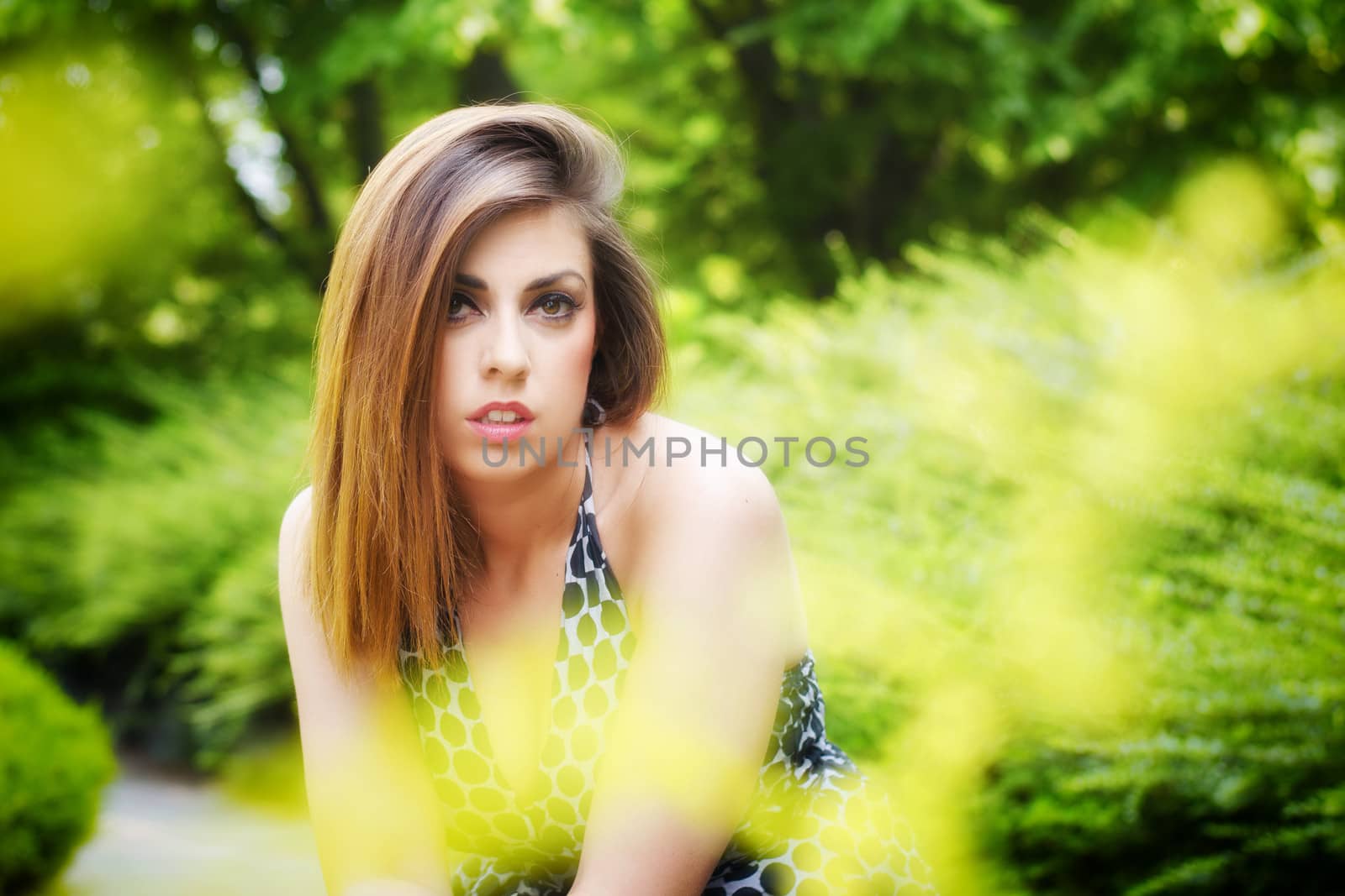 Pretty girl among flowers and green plants by artofphoto
