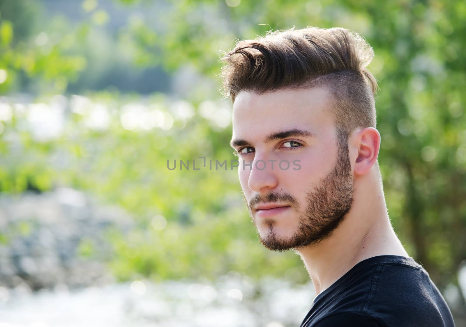 Portrait of attractive young man outdoors, looking in camera