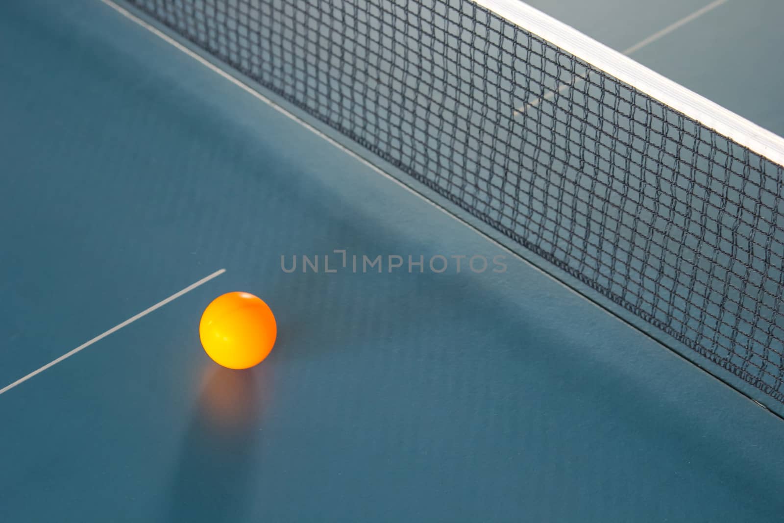 Orange table tennis ball on blue table