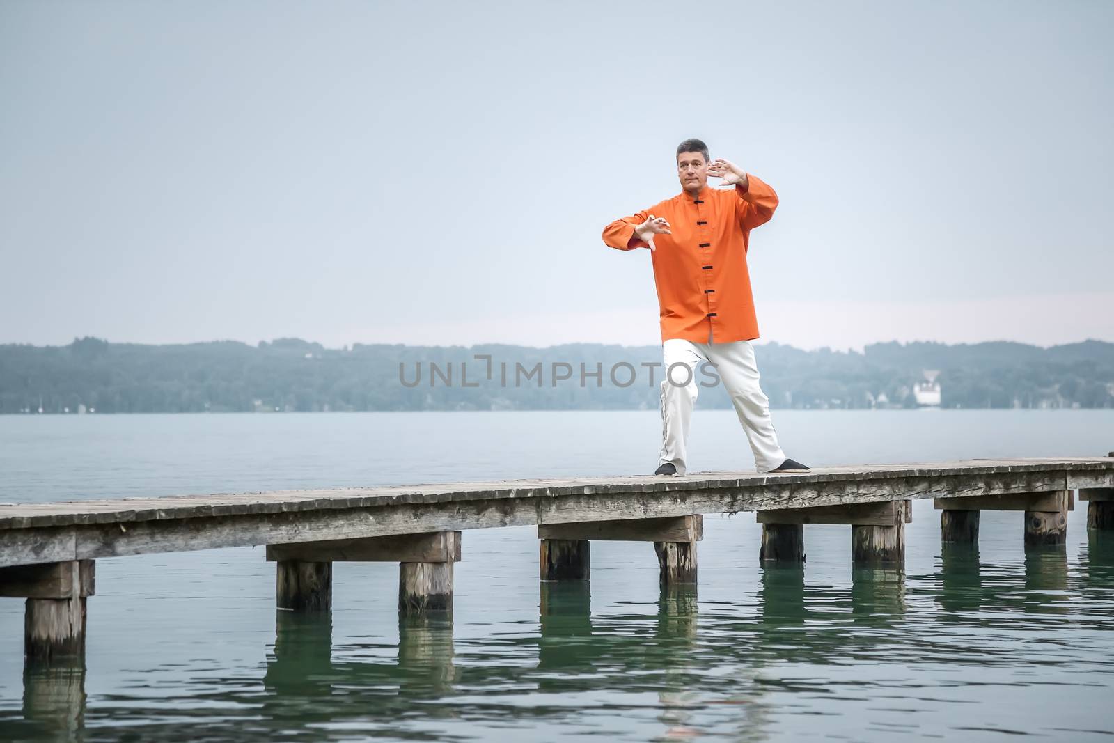 A man doing Qi-Gong in the early morning at the lake Starnberg