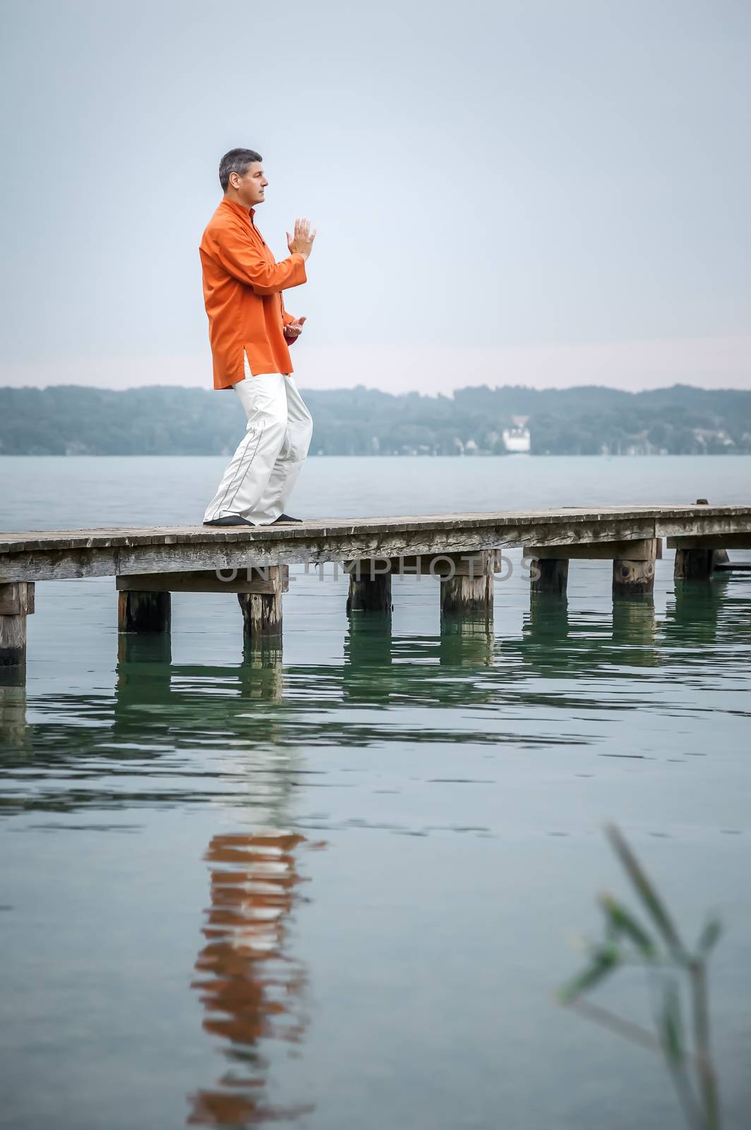 A man doing Qi-Gong in the early morning at the lake Starnberg