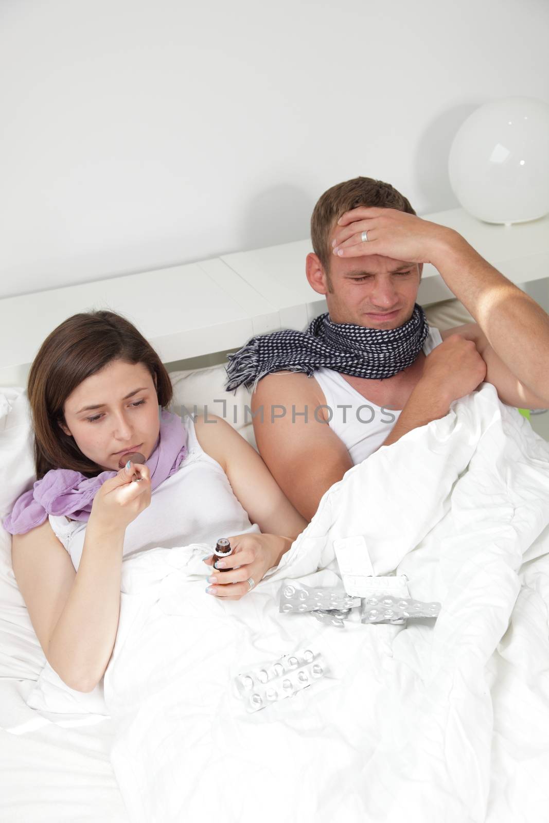 Close up portrait of sick couple lying in bed