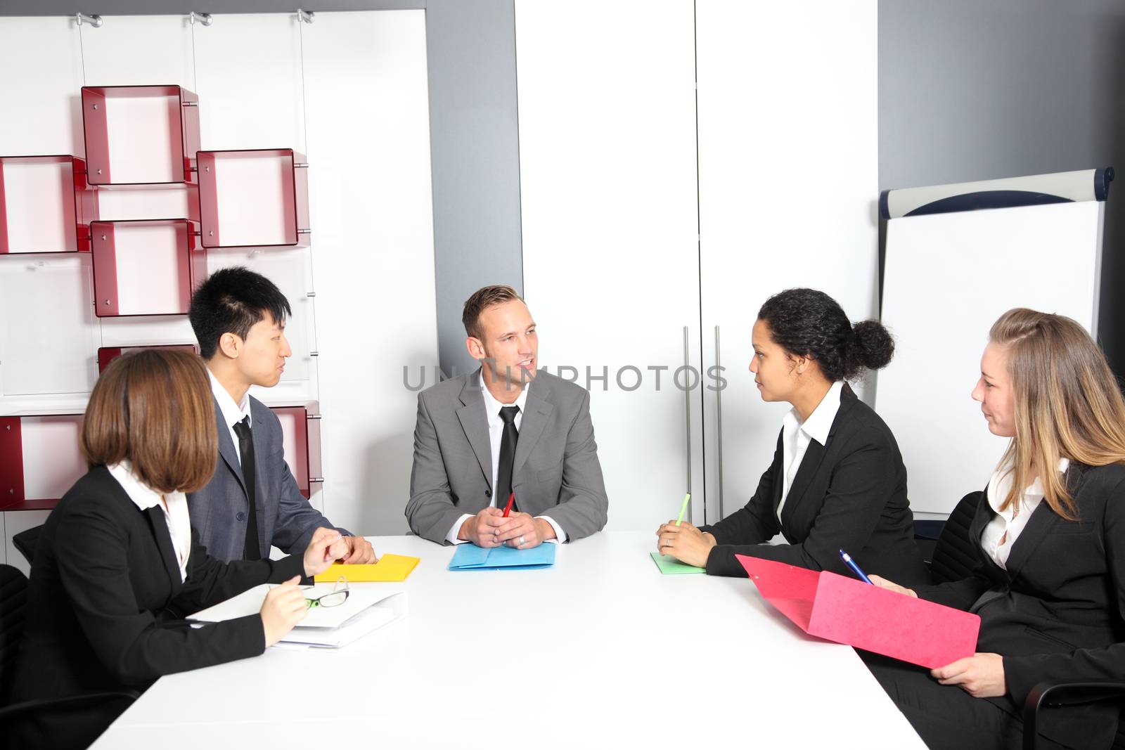 Portrait of confident colleagues communicating with their boss at meeting