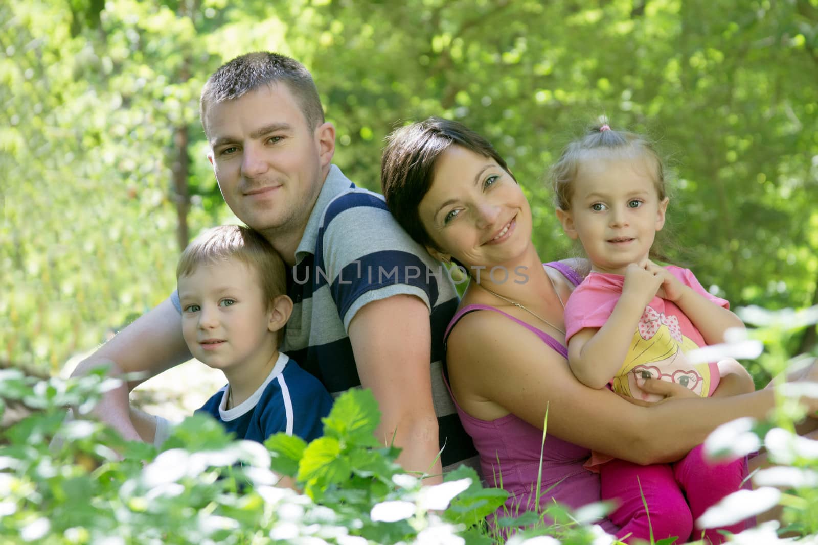 Happy family with two children sitting in grass