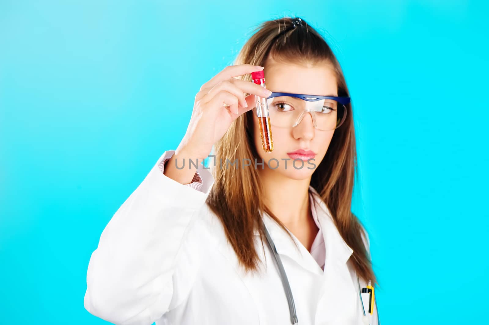 Woman looking at the chemical tube, focus on tube