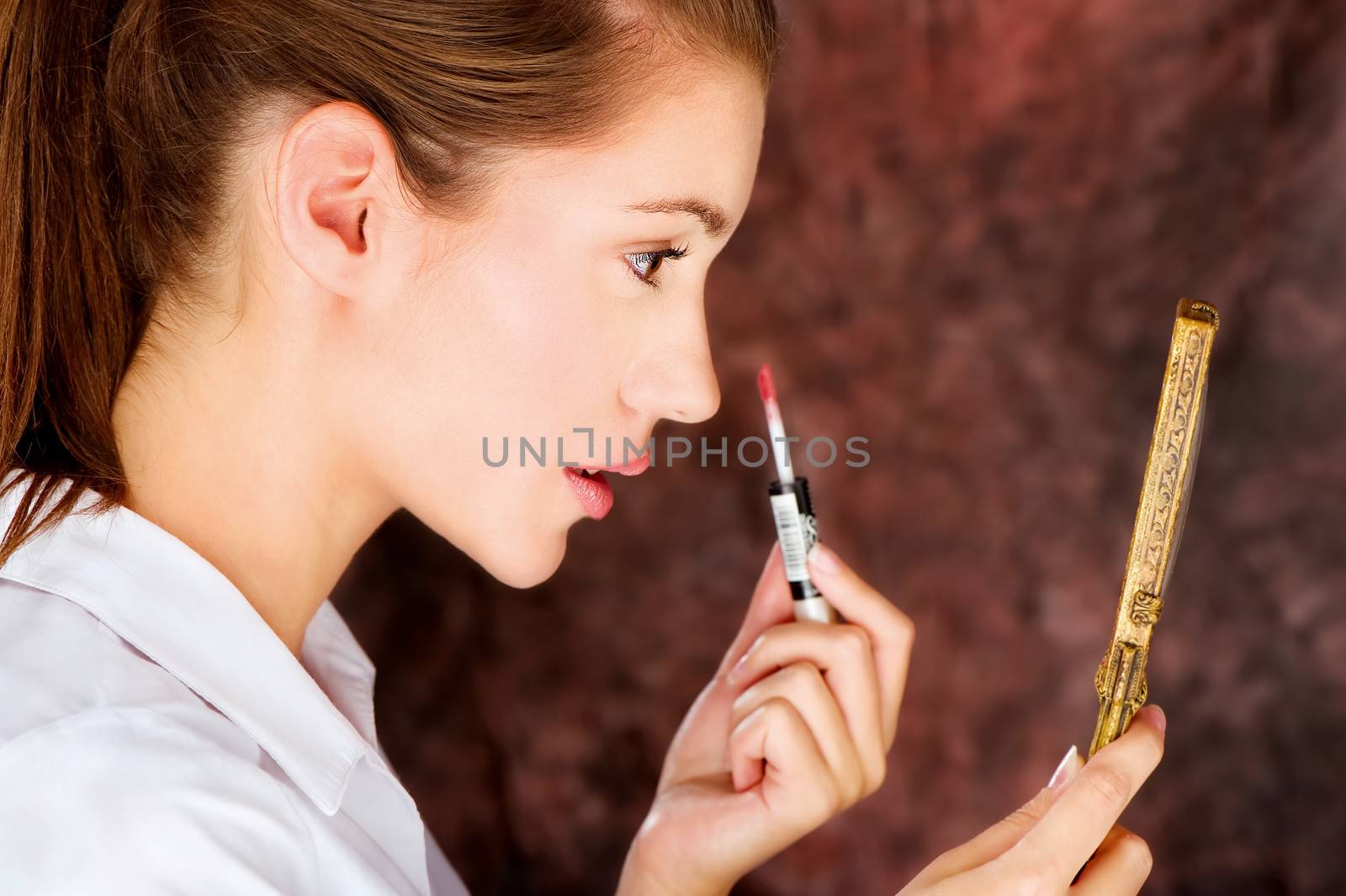 brunette applying lipstick by imarin