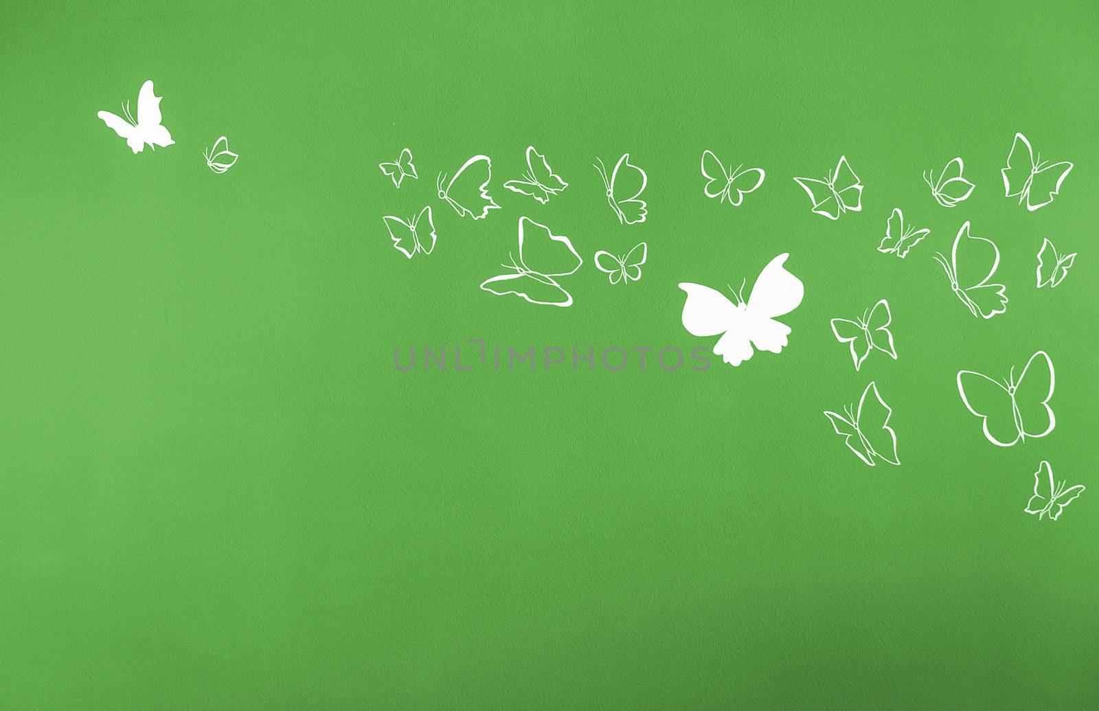 Group of white silhouettes butterflies flying over a green background