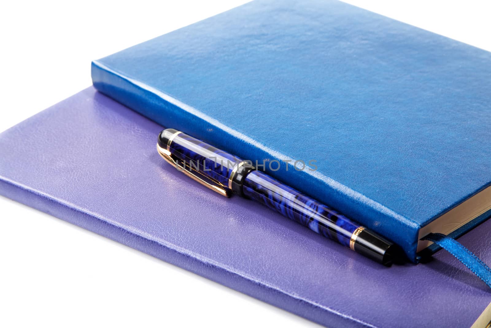 Dark blue writing-books and fountain pen isolated on a white background