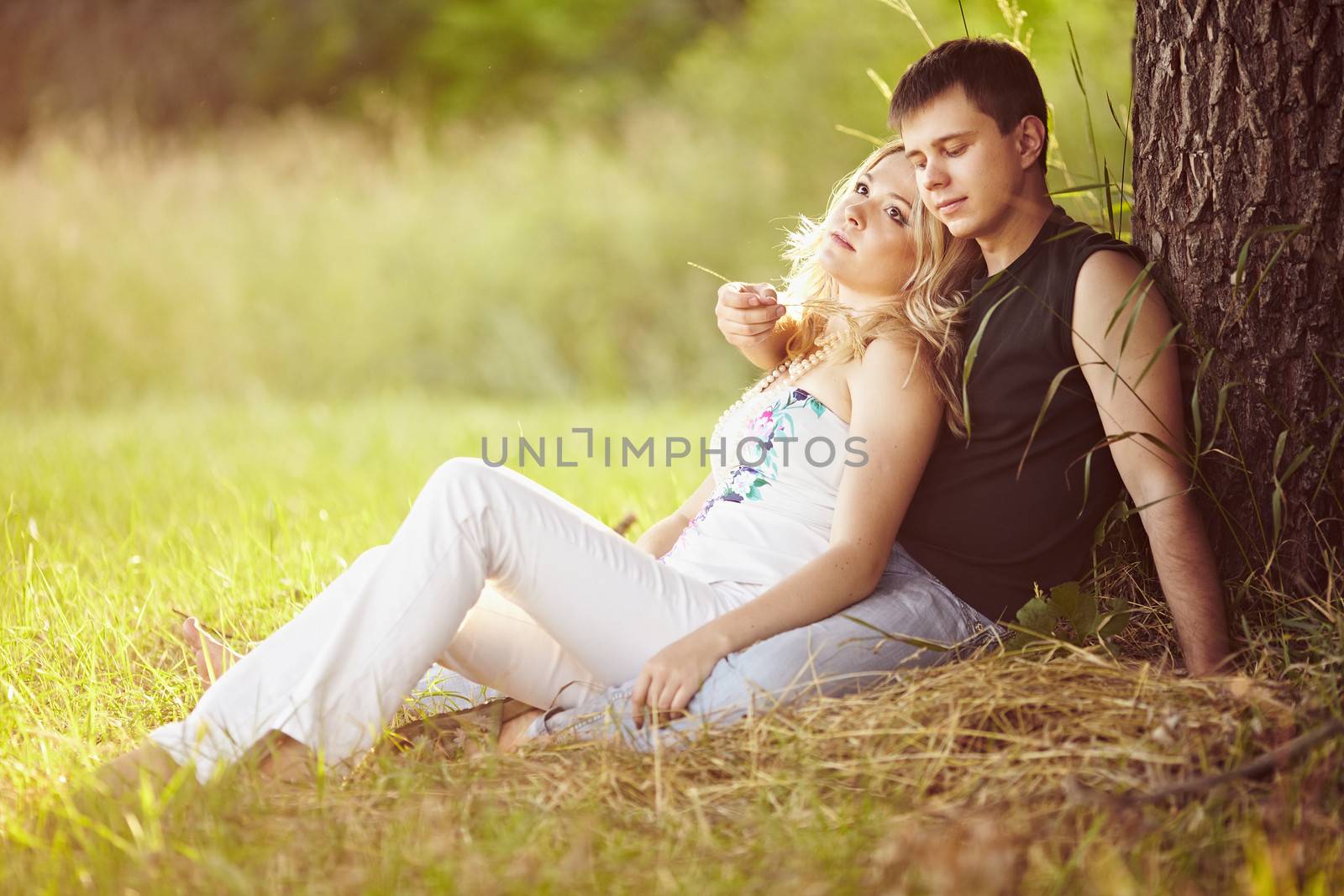 Young guy with a girl under the tree.