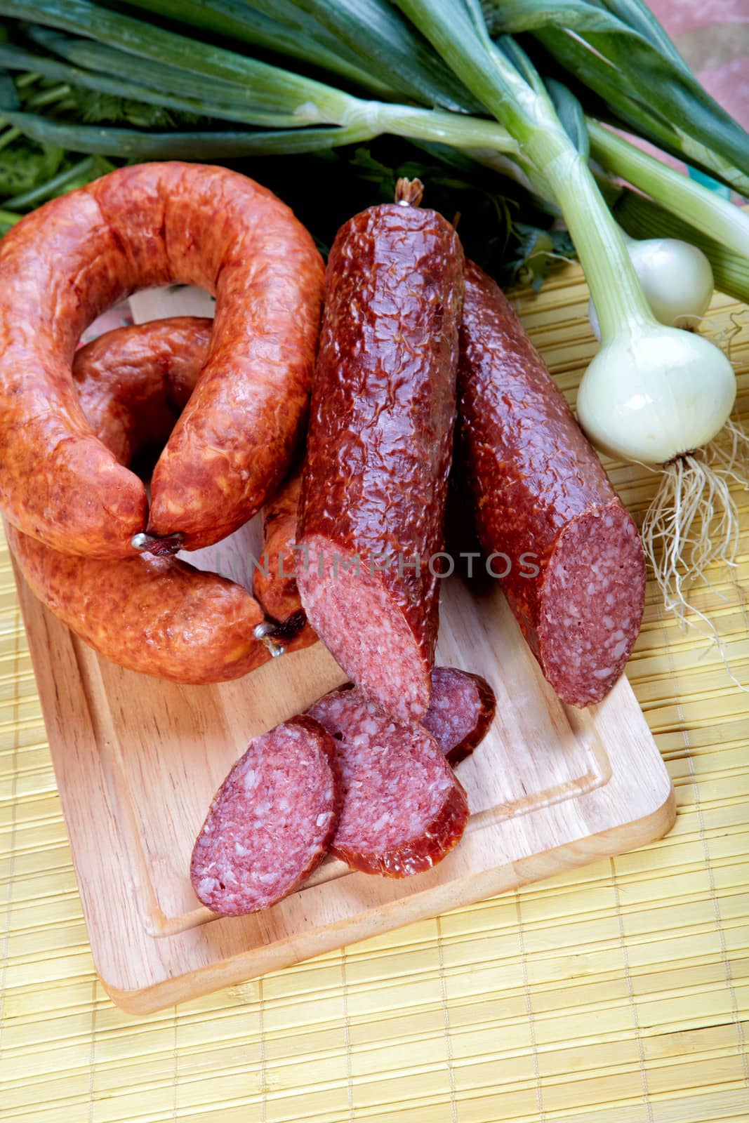 Still-life with smoked sausage and an onions on a kitchen table