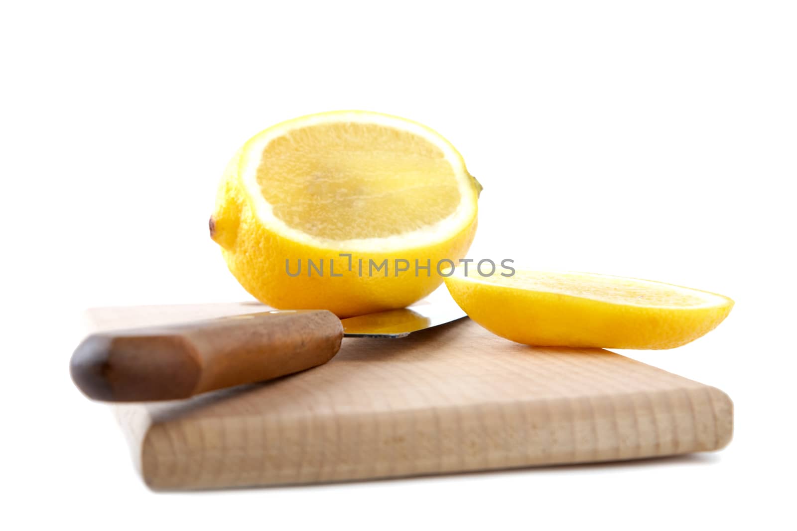 Knife and the cut lemon on a chopping board isolated on a white background