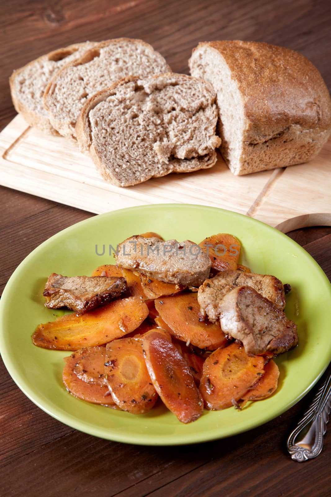 Dish with meat and carrots the cut bread on a kitchen table