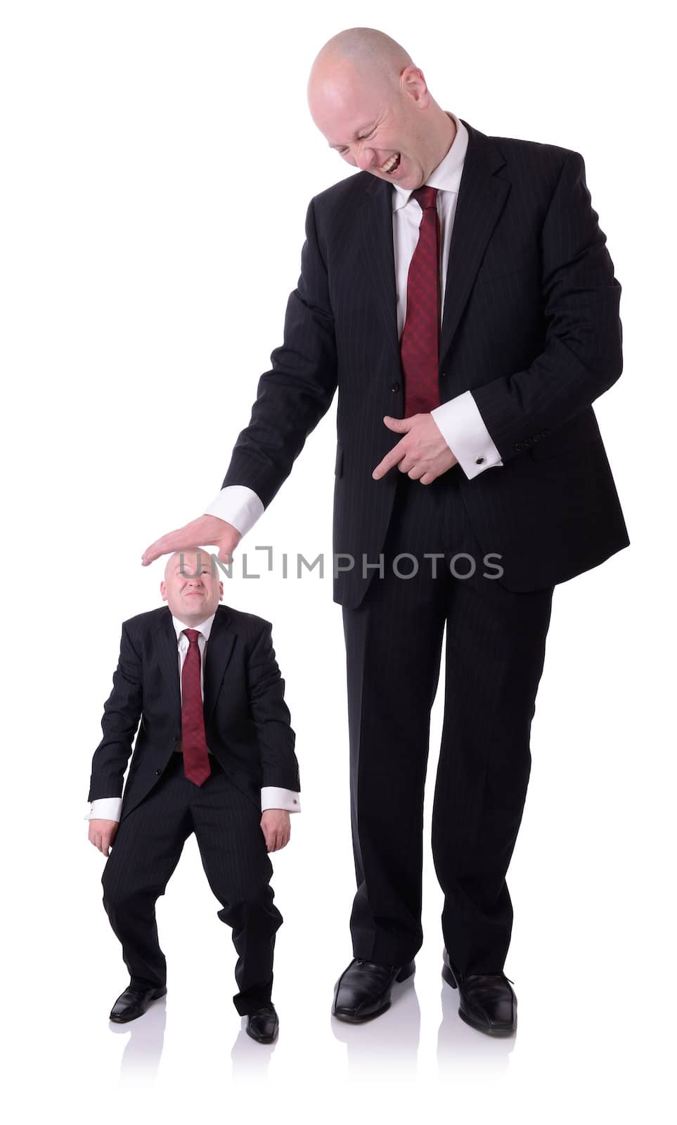 under the thumb businessman pushing down on a businessman isolated on white