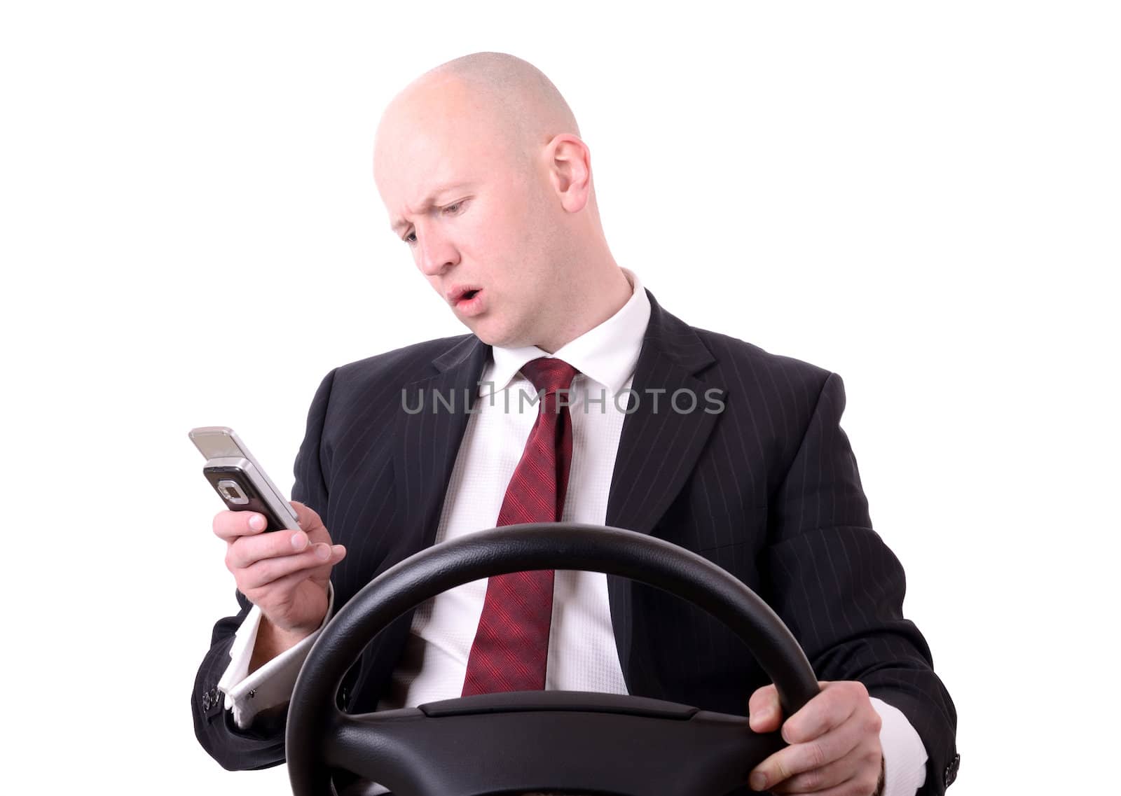 a businessman distracted by mobile phone when driving isolated on white
