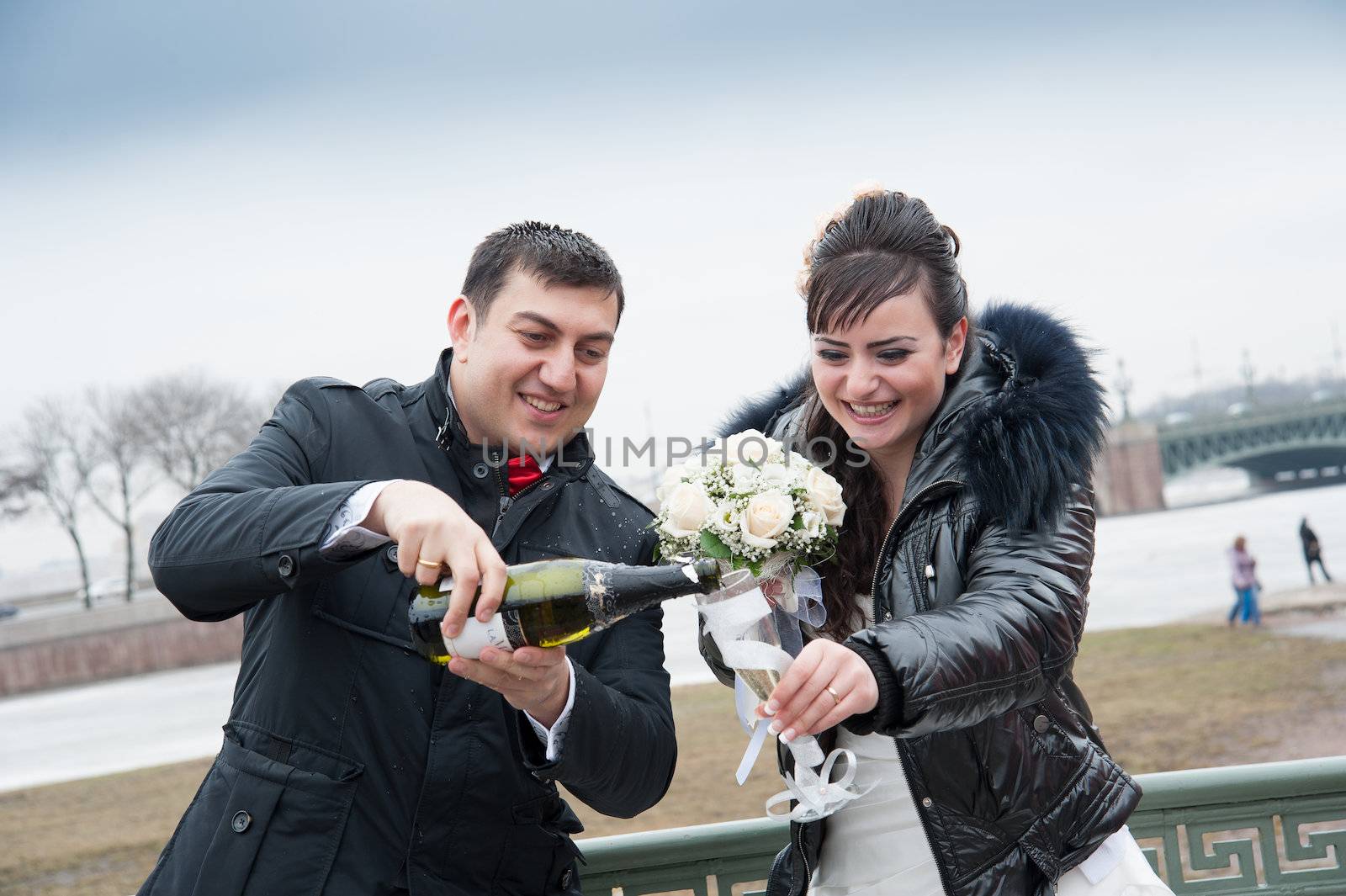 bride and groom drinking champagne by raduga21