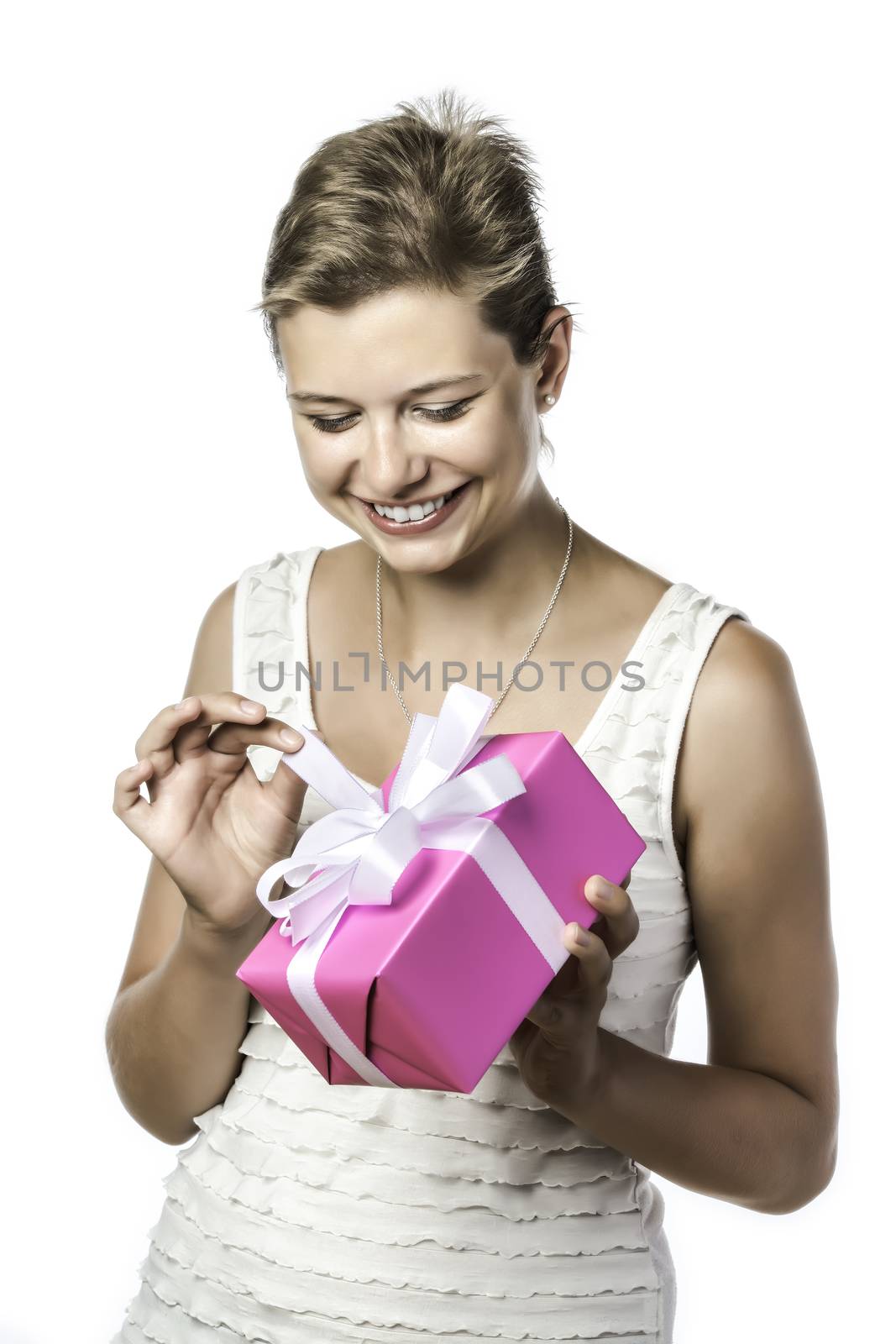 Young pretty woman holding a gift and unwraps it, isolated on white background