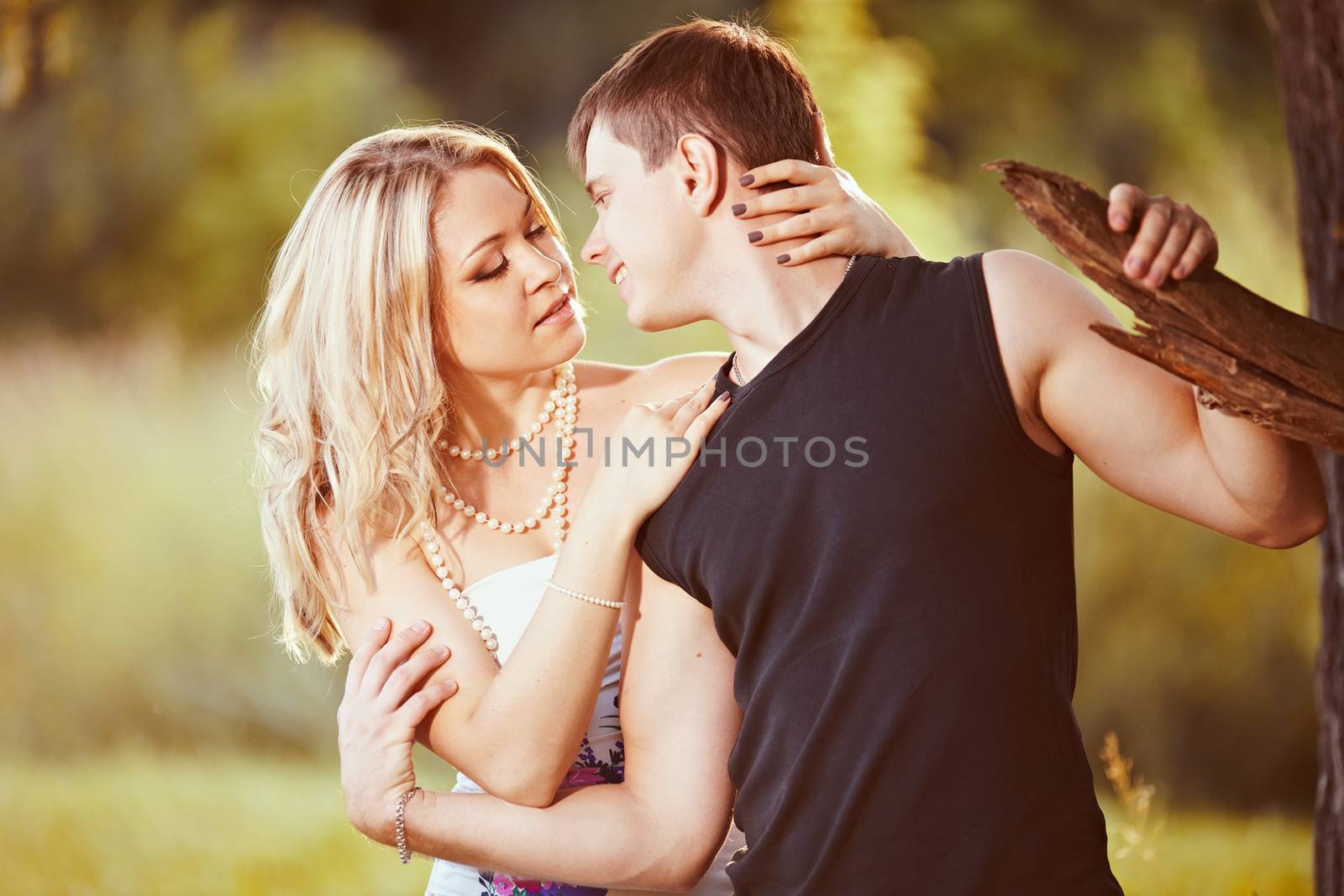 Young man near a tree in front of a kiss.