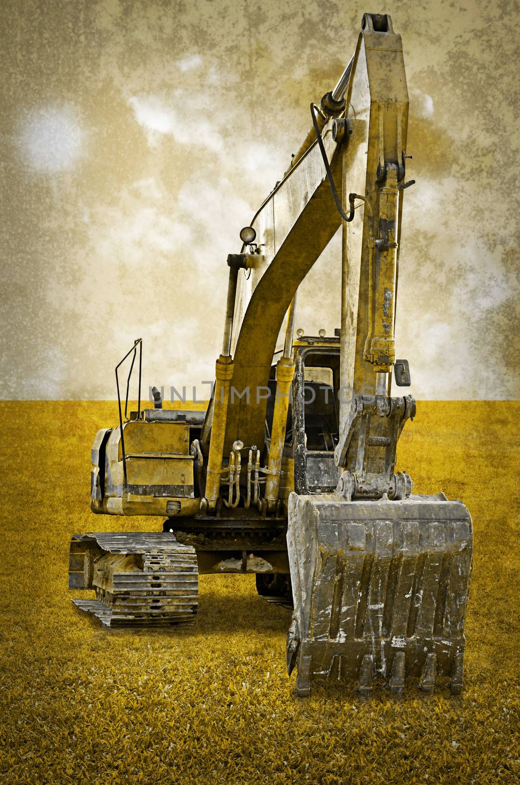 Track-type loader excavator machine on green grass field