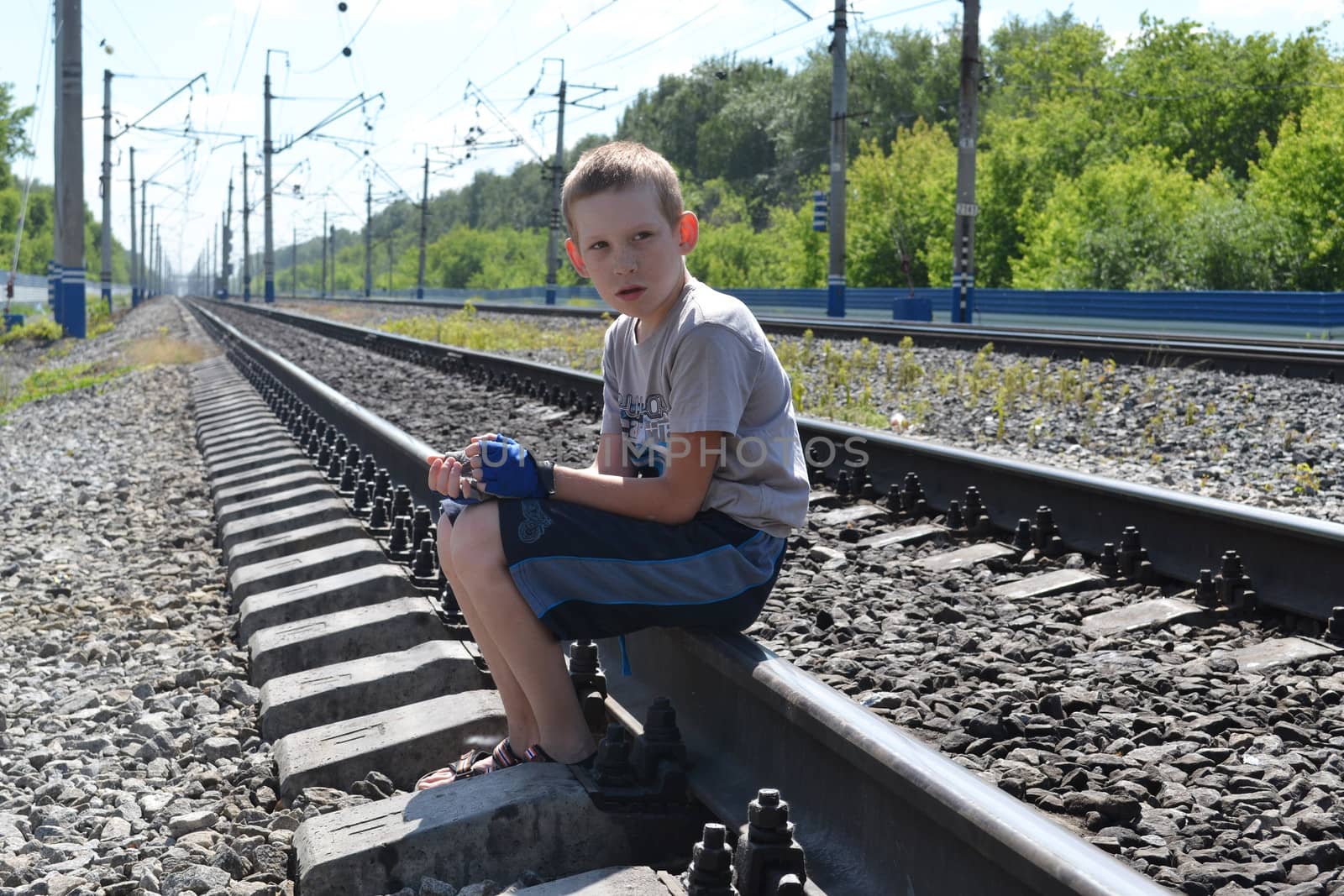 the sad boy sits on rails