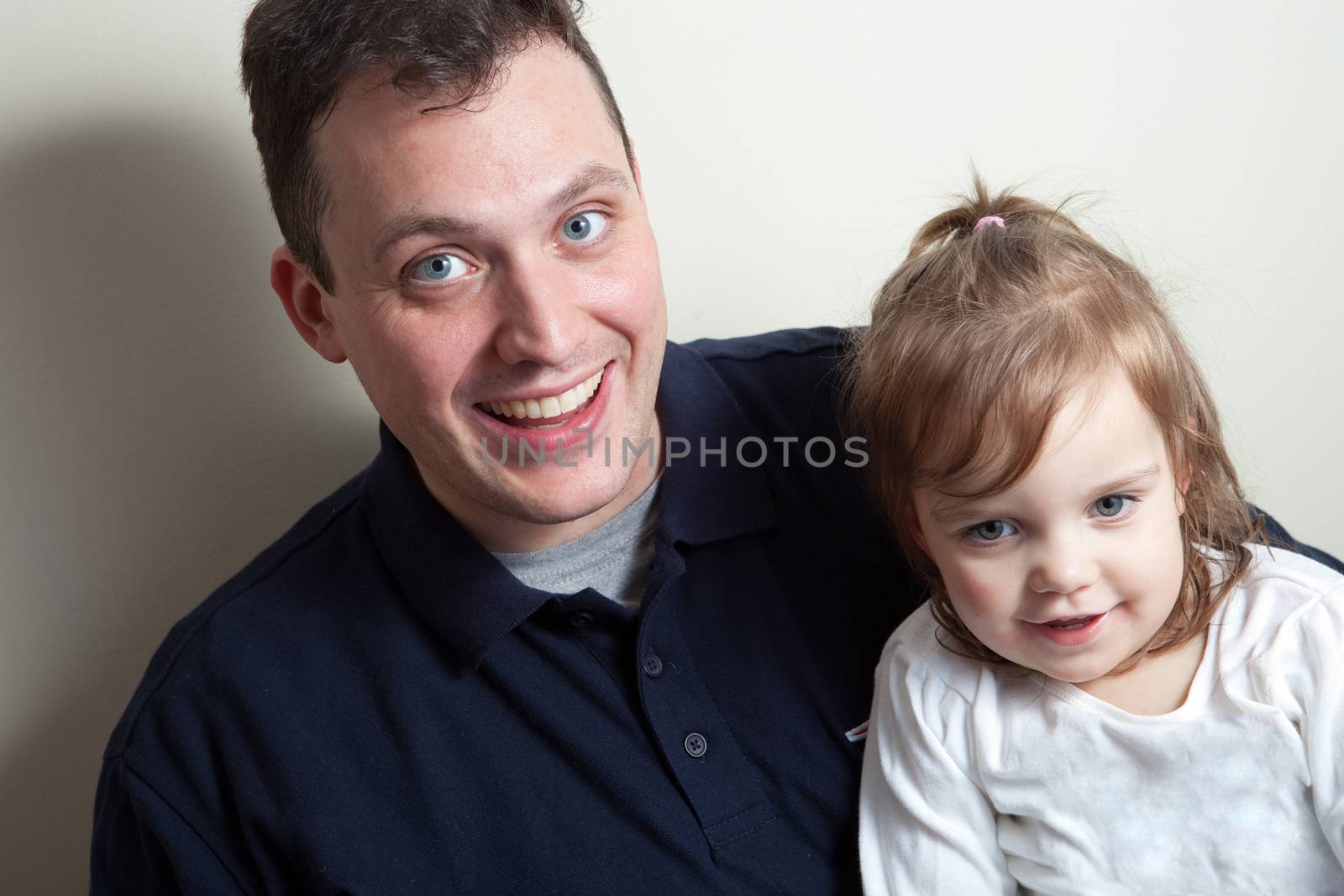 A young happy toddler aged little girl posing with her daddy.