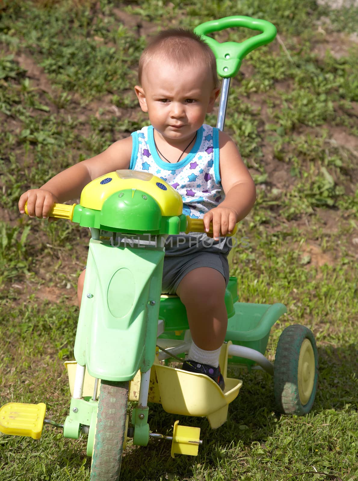 The little boy on a toy motorcycle in the afternoon