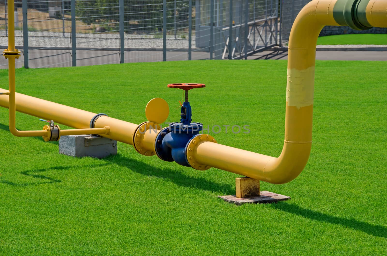 Image of main gas pipe valve overlap on a background of green grass.