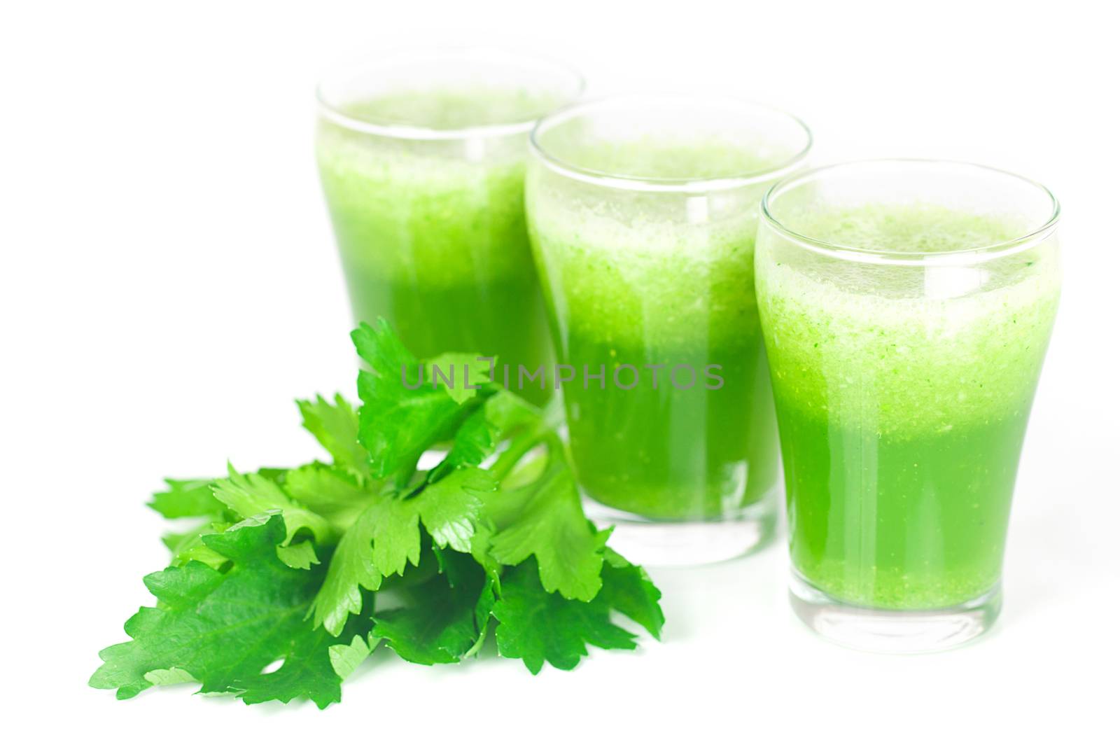 celery and three glasses with celery juice isolated on white by jannyjus