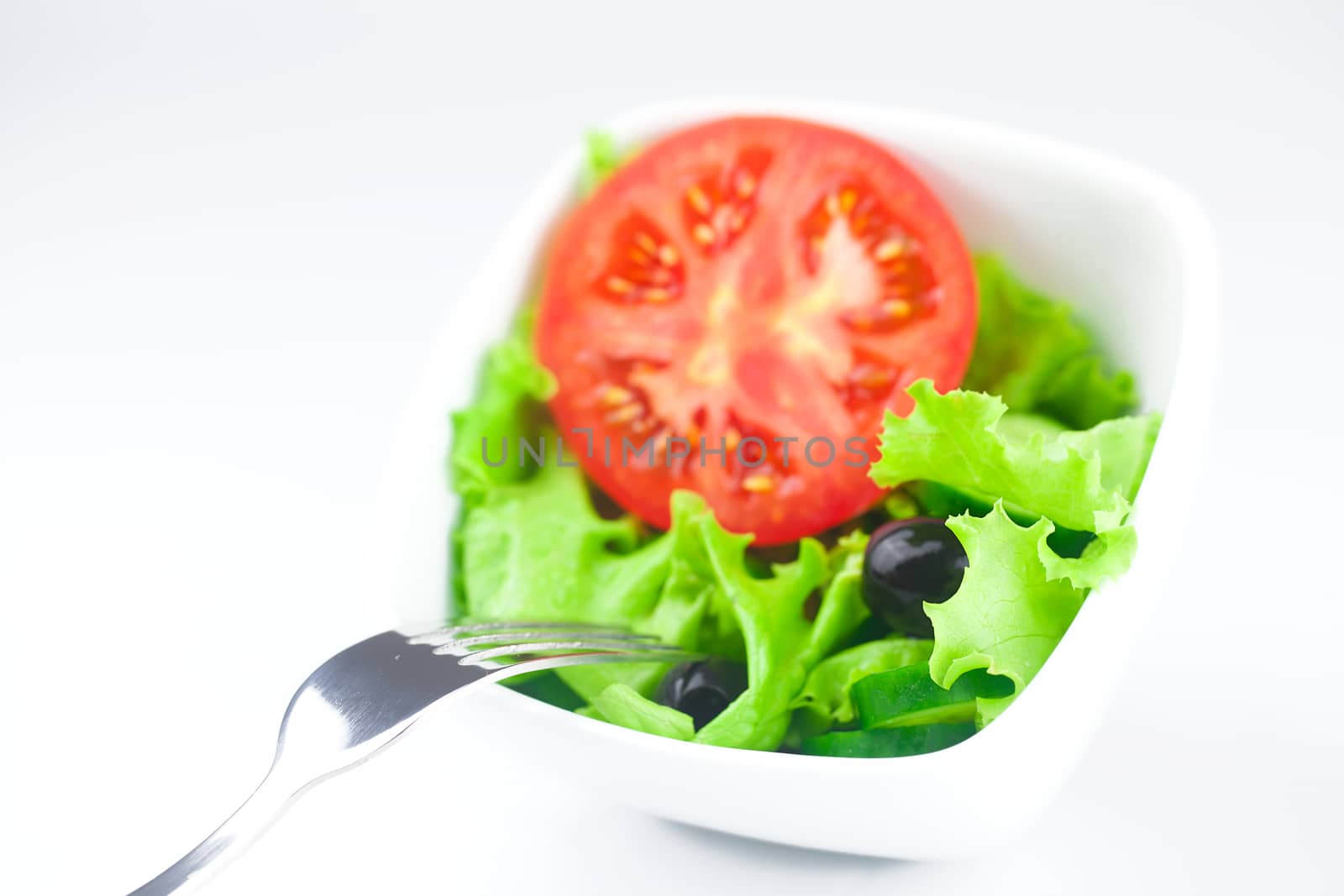 fork,black olive,lettuce, tomato, cucumber and pepper in a bowl by jannyjus