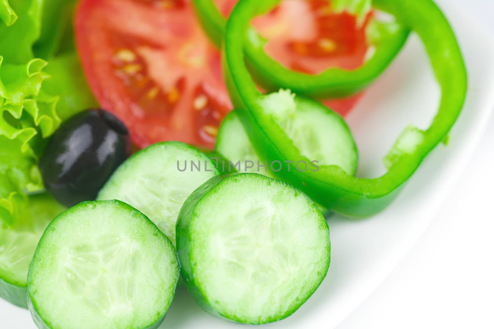 black olive,lettuce, tomato, cucumber and pepper in a bowl