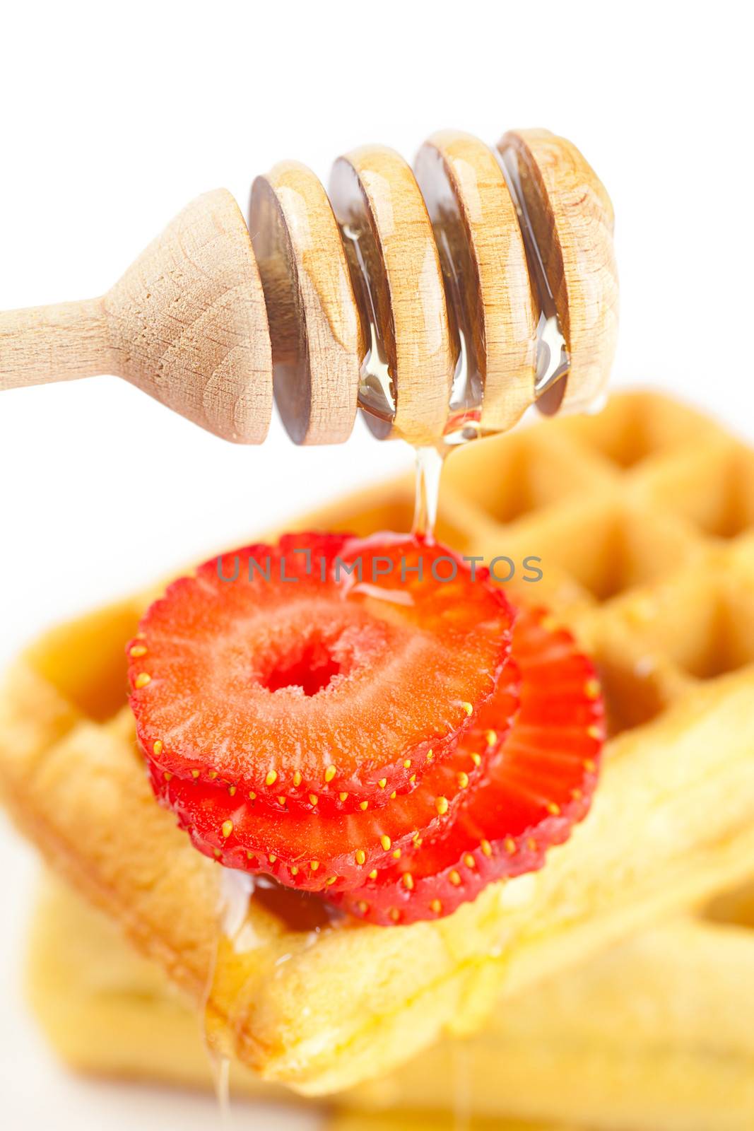 Belgian waffles and strawberries on a plate, stick for honey and by jannyjus