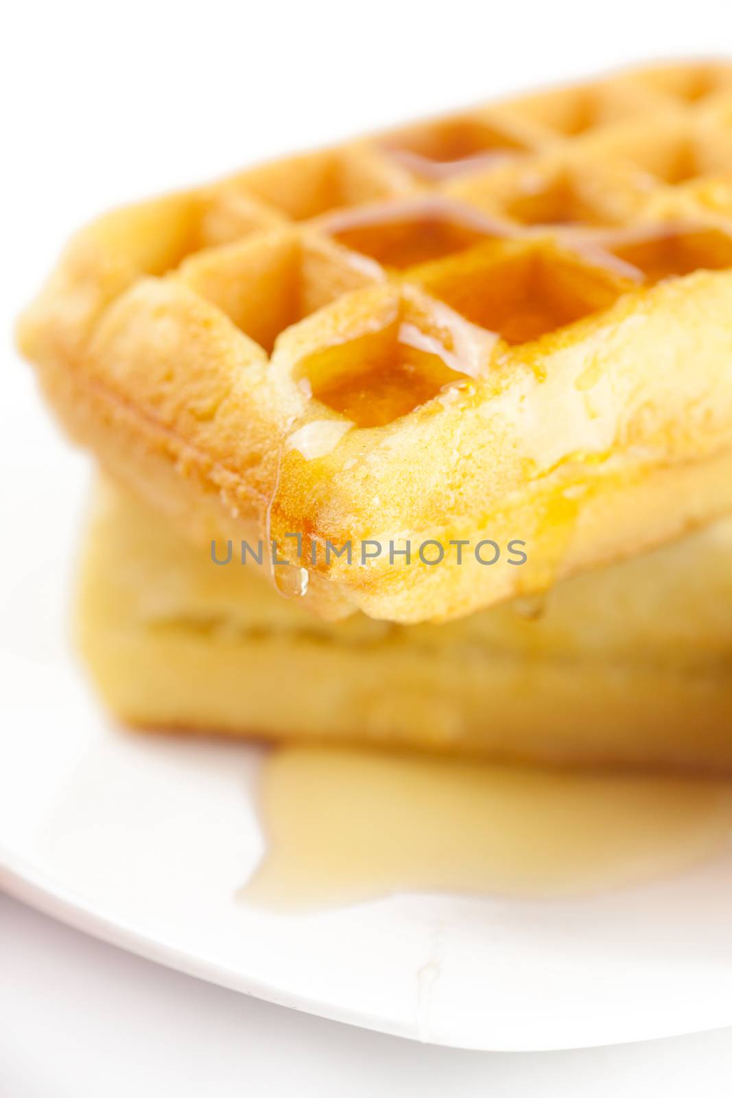 Belgian waffles and honey on a plate  isolated on white by jannyjus